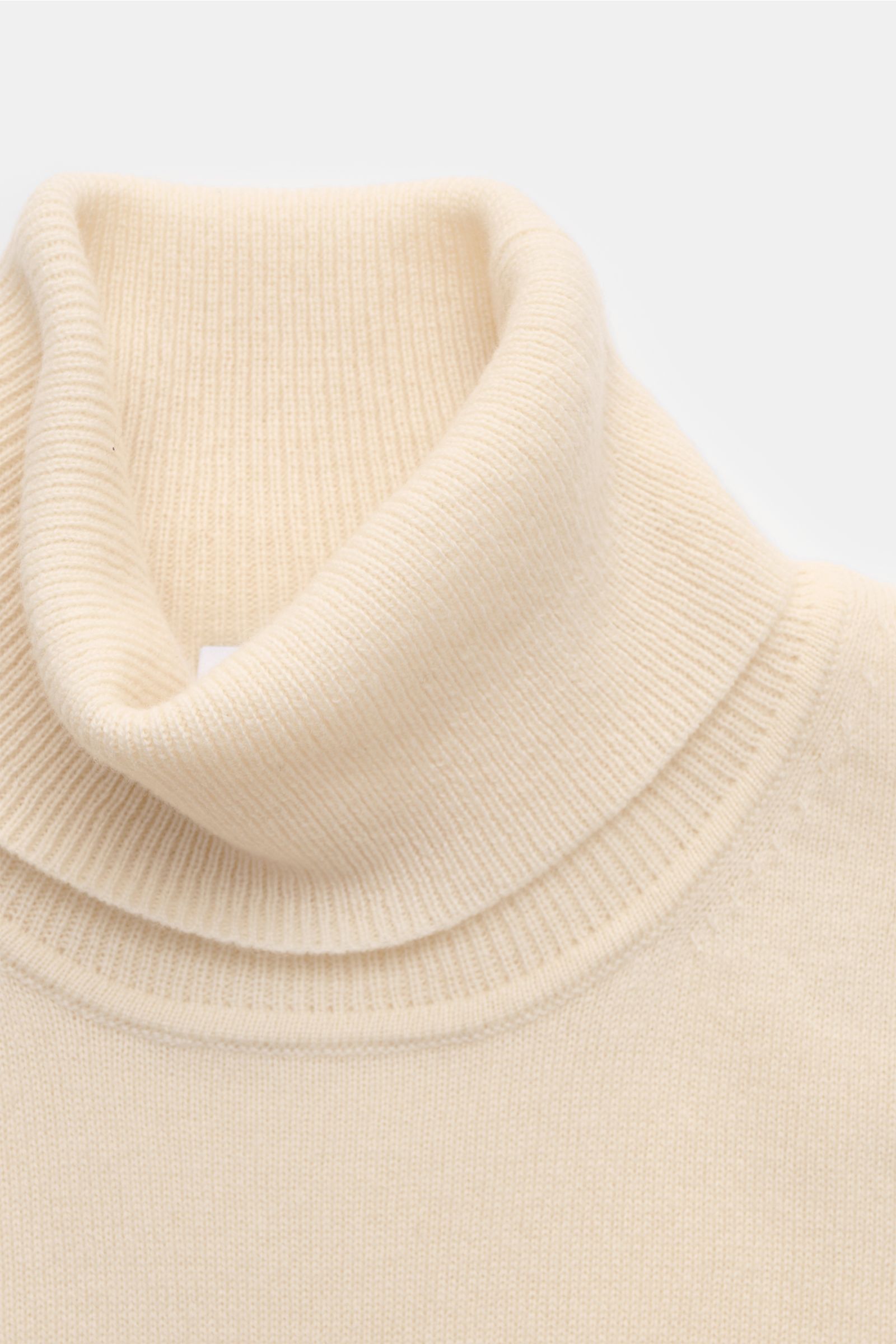Nahaufnahme aus schräger Draufsicht des von Braun Cashmere Rollkragenpullovers creme, Slim Fit, mit feinem Strickbild, weichem Griff und elastischen Rippbündchen.
