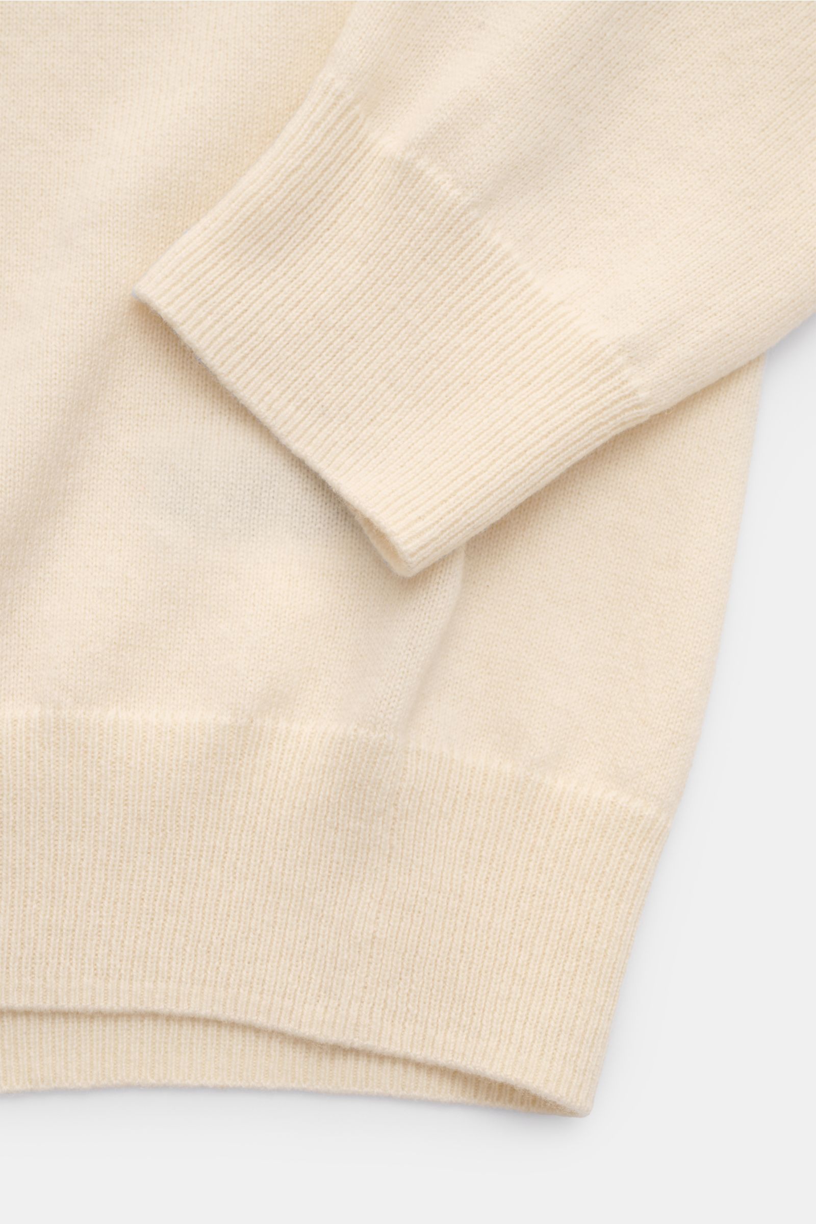 Nahaufnahme des von Braun Cashmere Rollkragenpullovers creme von schräg oben, feines Strickbild, elastische Rippbündchen, Slim Fit, sehr weich.