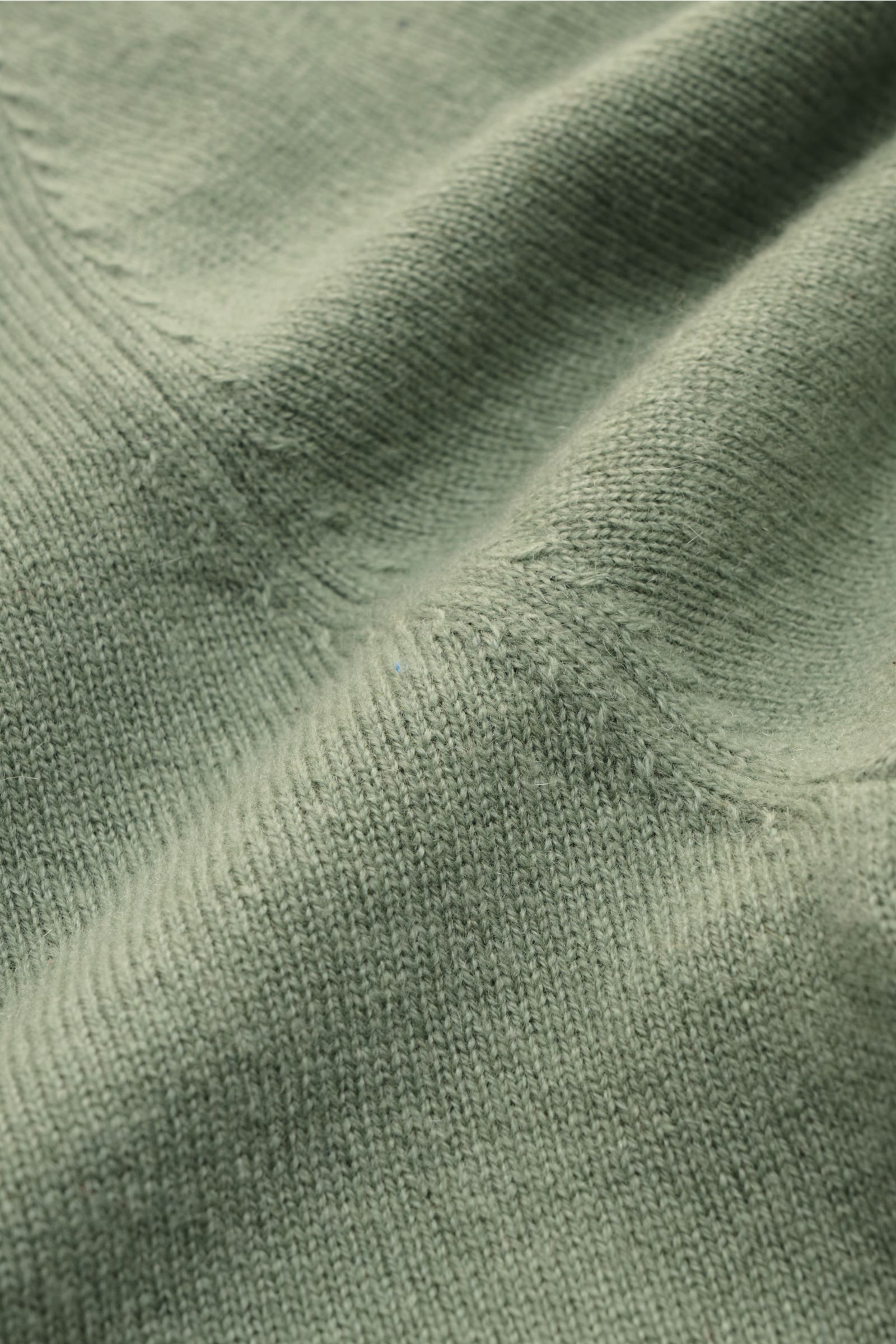 Nahaufnahme des feinen Strickbilds und der geschmeidigen Struktur des graugrünen von Braun Cashmere Rollkragenpullovers aus reinem Cashmere.