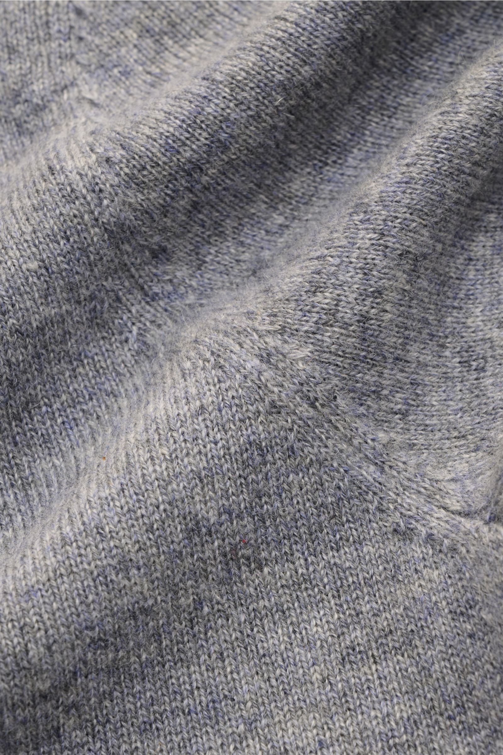 Nahaufnahme des von Braun Cashmere Rollkragenpullovers grau meliert, feines Strickbild, weicher Griff, elastische Rippbündchen sichtbar.