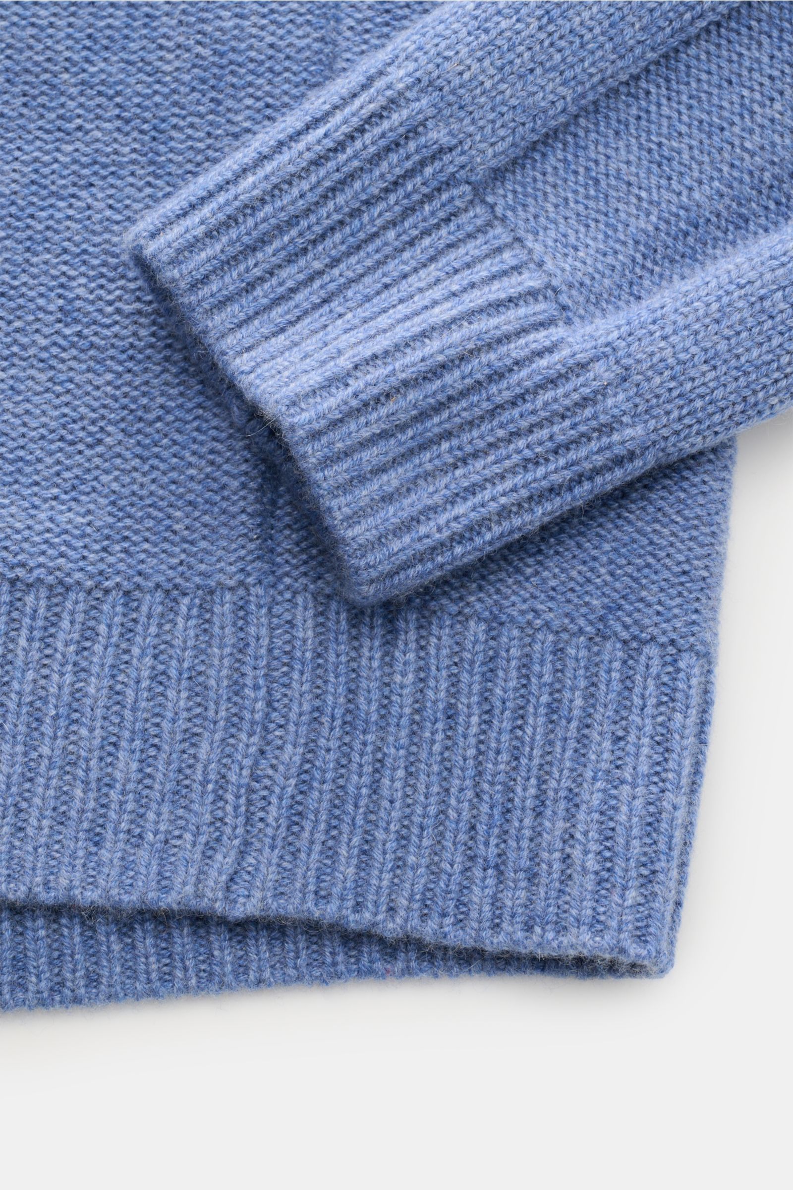 Nahaufnahme des von Braun Cashmere Rollkragenpullovers blau meliert, zeigt feinen Linksstrick, Zopfmuster, Slim Fit, weichen Griff und flexible Rippbündchen.