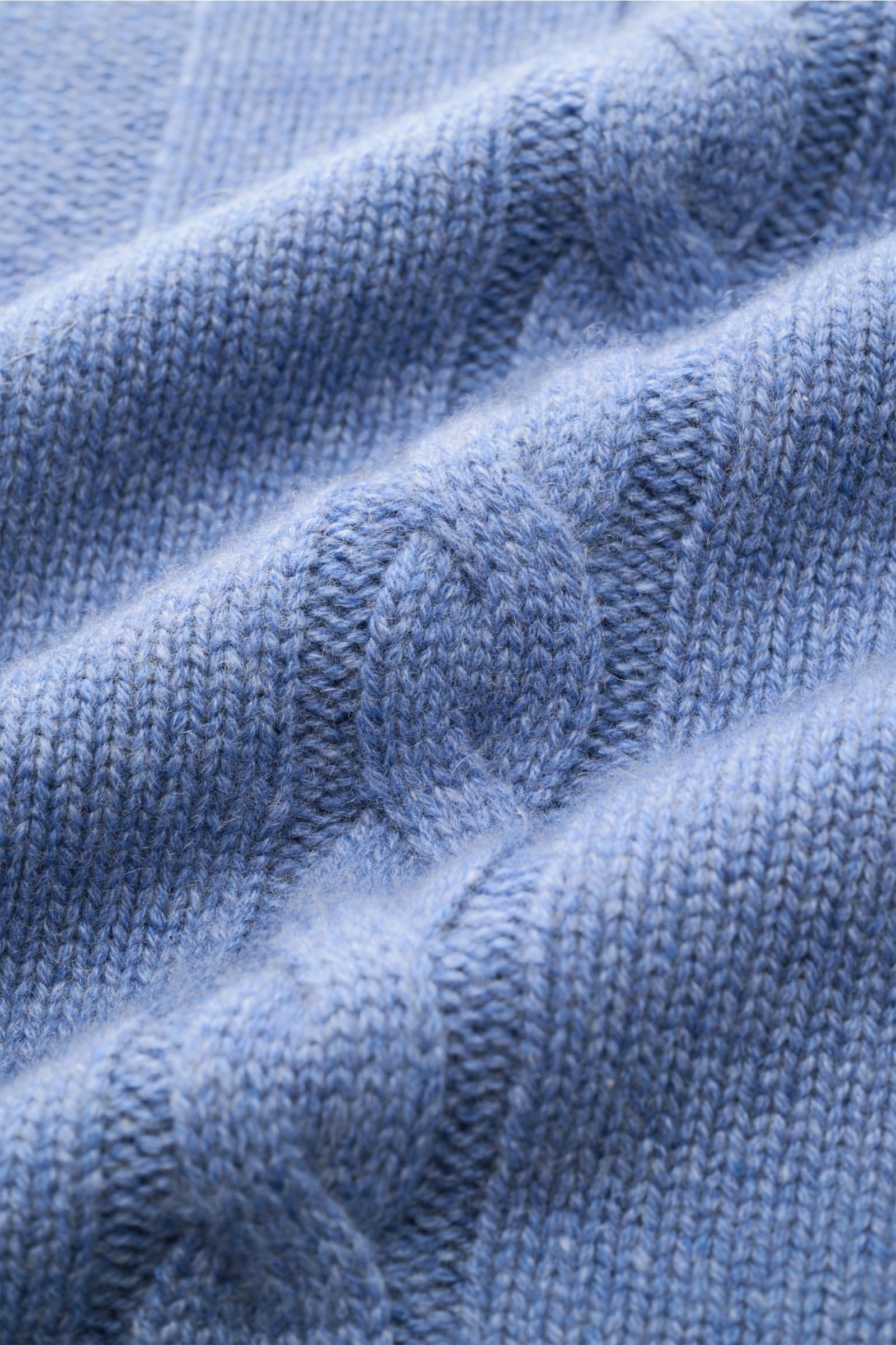 Nahaufnahme des von Braun Cashmere Rollkragenpullover blau meliert mit feinem Links- und Zopfstrickmuster, weicher Griff.