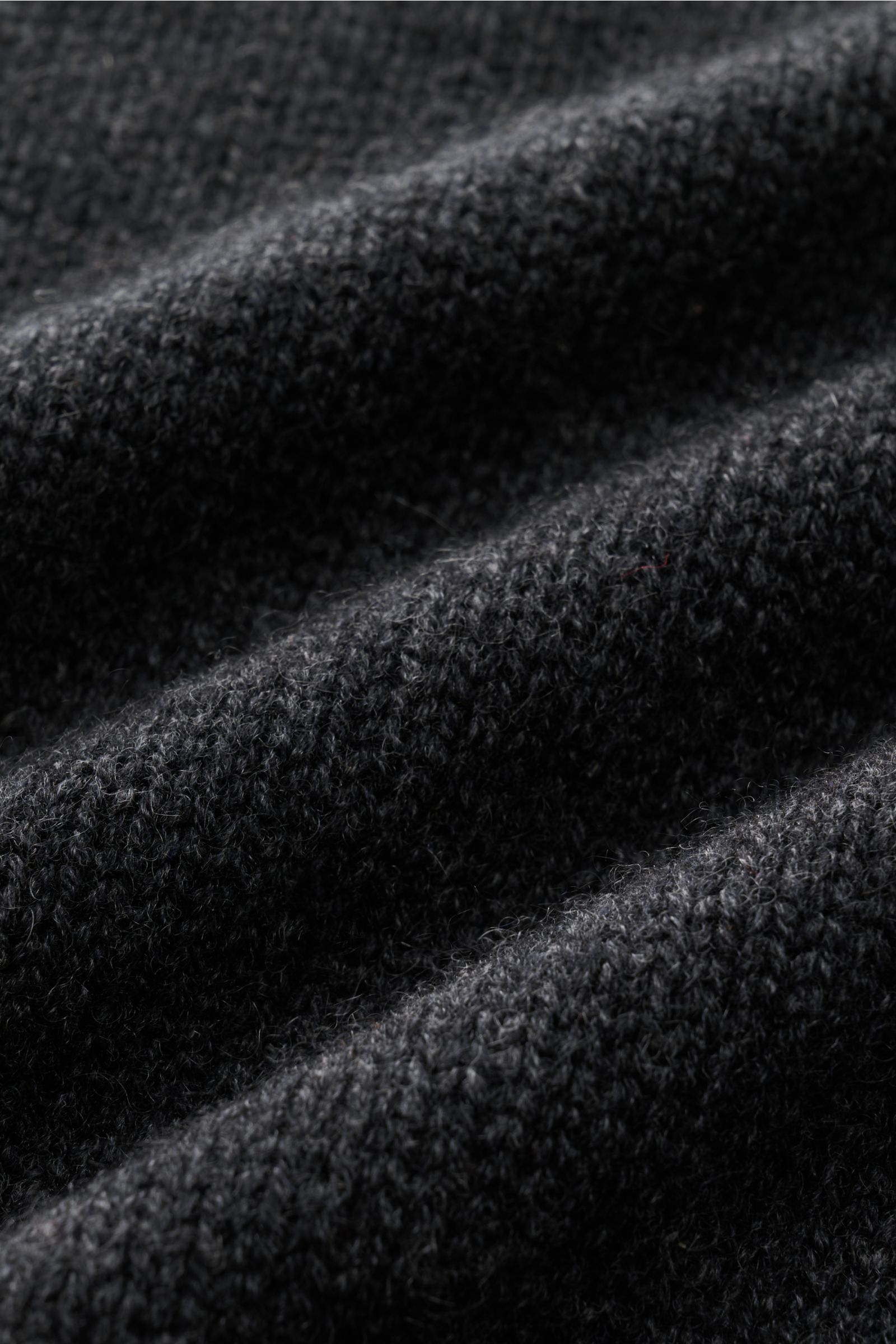 Nahaufnahme des von Braun Cashmere Troyer dunkelgrau meliert, Detailaufnahme des mittelfeinen, sehr weichen Strickbilds mit sportiven Rippstrick-Details.