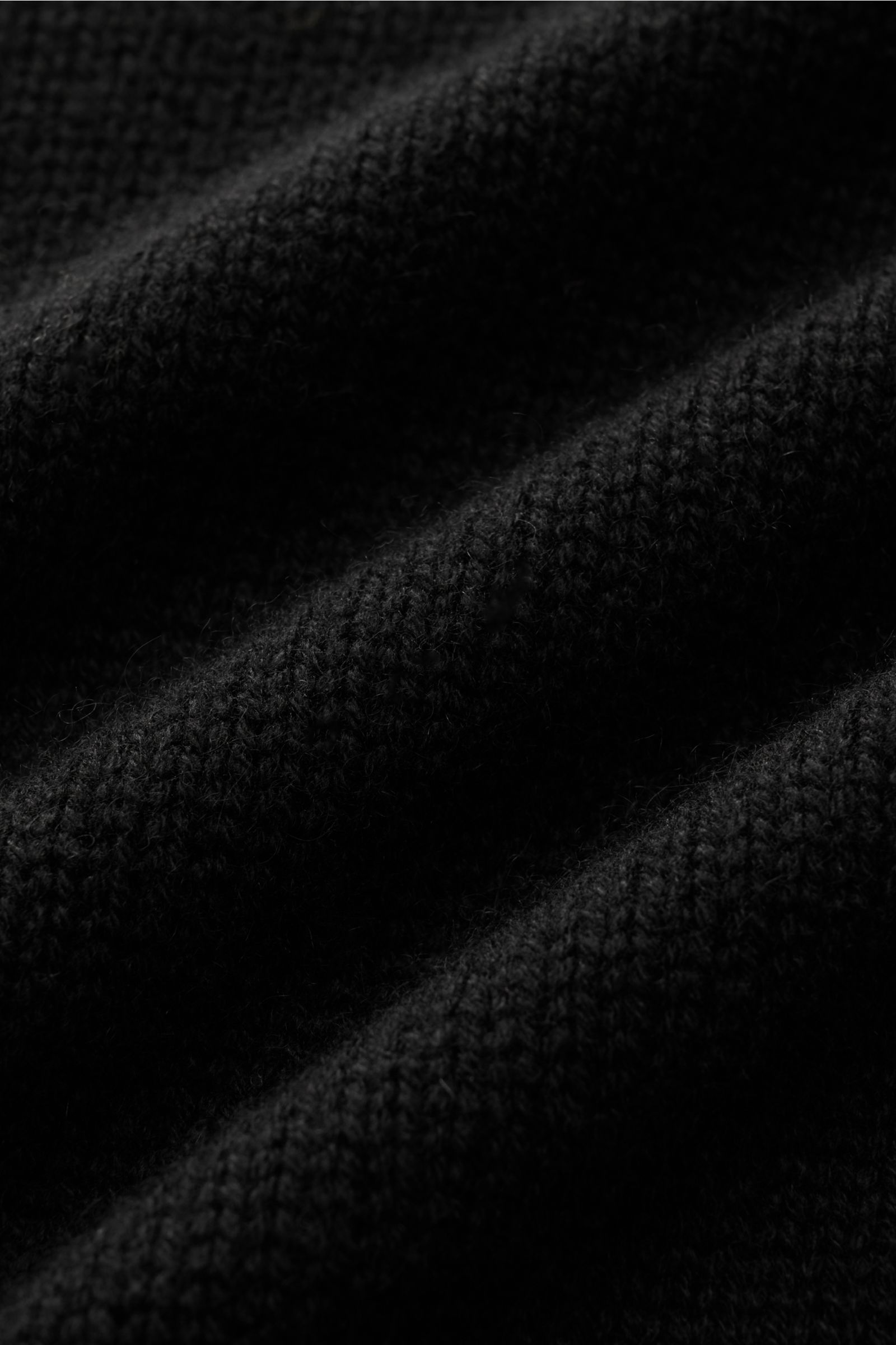 Nahaufnahme des feinen, mittelfeinen Strickbilds vom von Braun Cashmere Troyer schwarz mit weichem Griff und sportiven Rippstrick-Details.