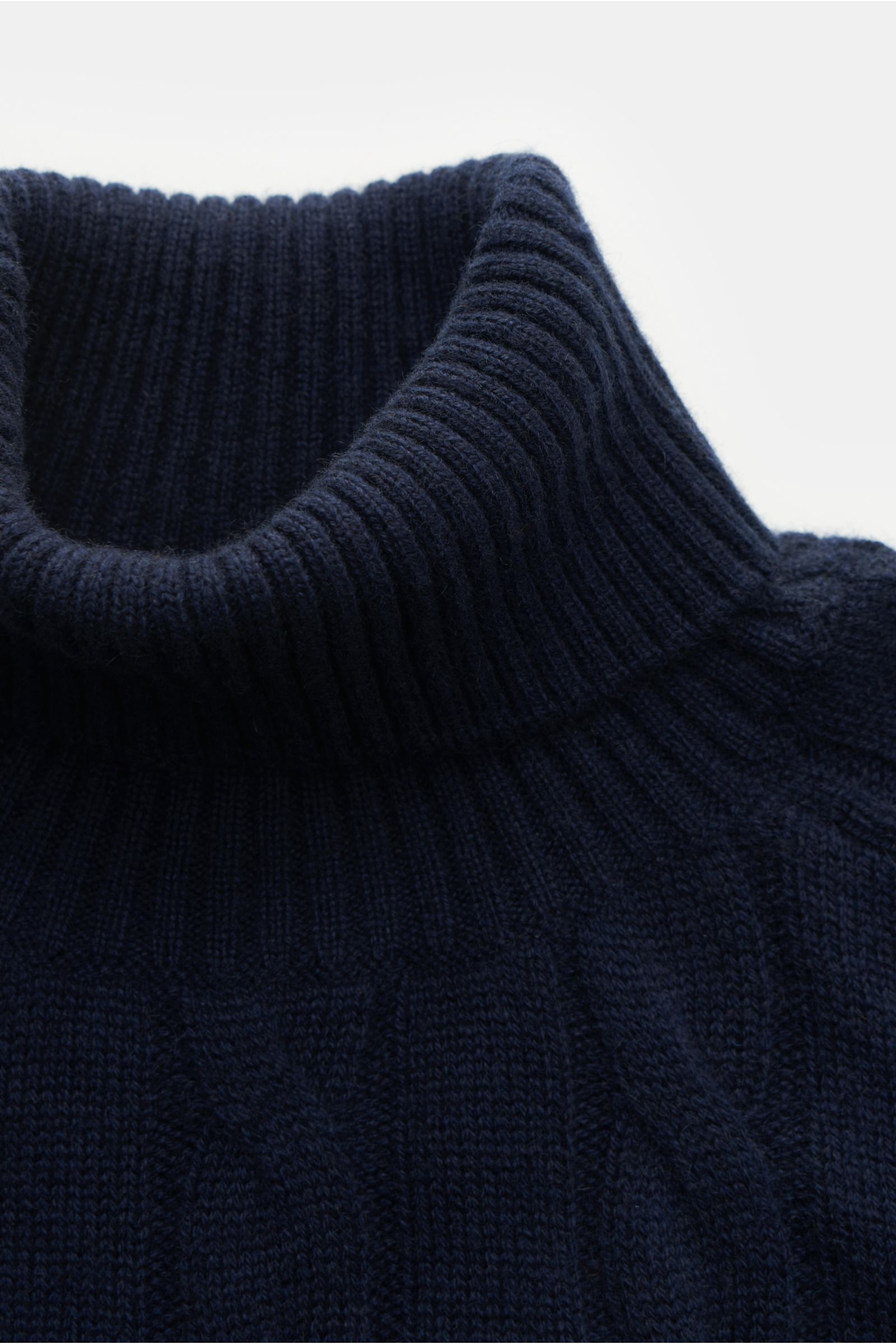 Nahaufnahme des von Braun Cashmere Rollkragenpullovers navy, zeigt anliegenden Rollkragen mit flexiblem Rippbündchen und zeitlosem Zopfstrickmuster.