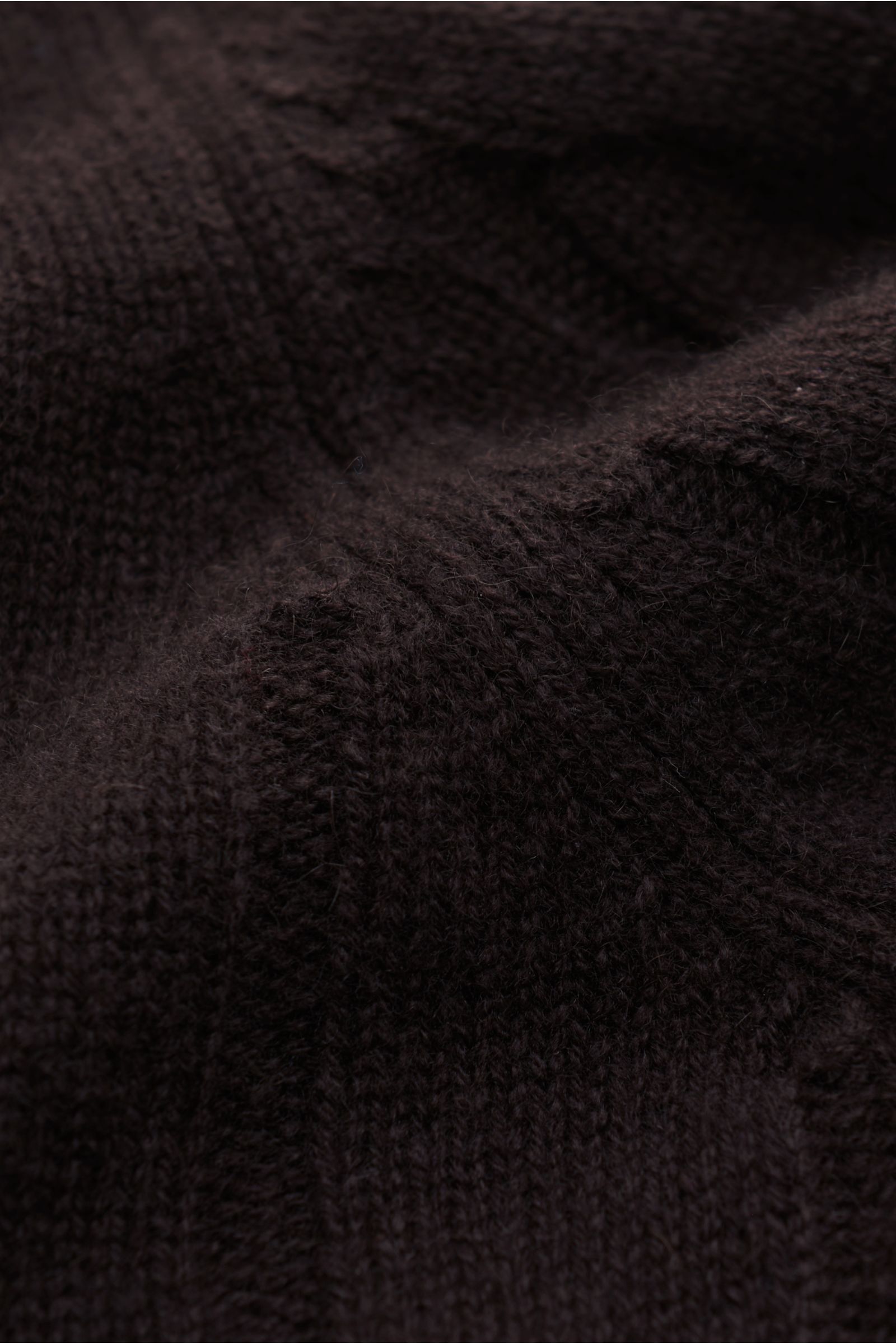 Nahaufnahme des von Braun Cashmere Rollkragenpullovers dunkelbraun, weiches, zeitloses Zopfstrickmuster aus reiner Mongolischen Cashmere, Regular Fit, anliegender Rollkragen, flexible Rippbündchen.