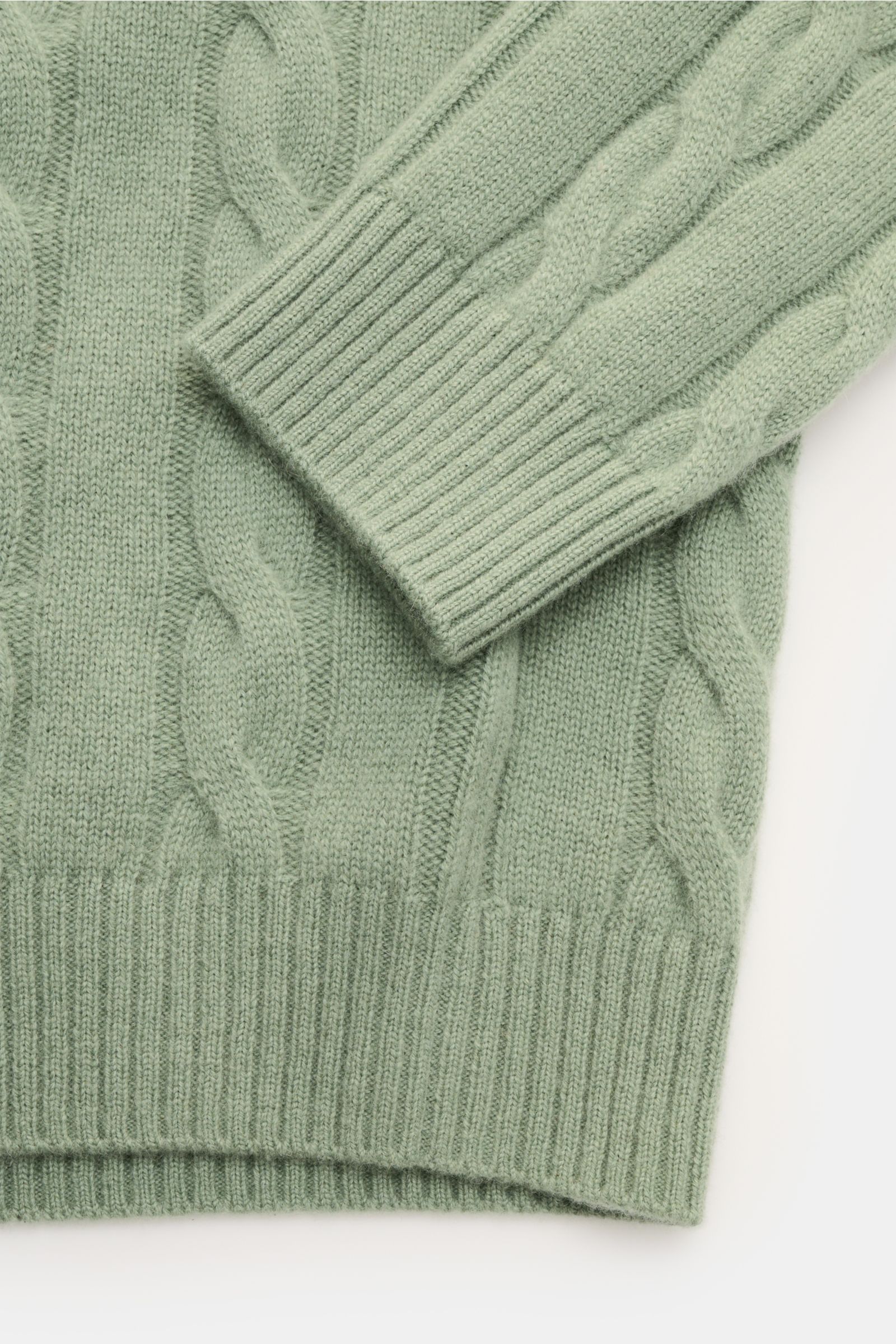 von Braun Cashmere Rollkragenpullover graugrün, Detailfoto aus schräger Draufsicht mit klassischem Zopfstrickmuster, weichem Griff, Regular Fit, anliegendem Rollkragen und flexiblen Rippbündchen aus reinem Cashmere.
