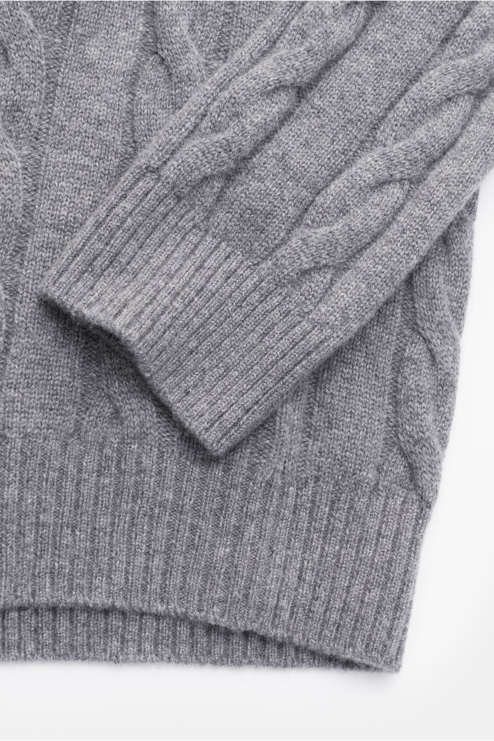 von Braun Cashmere Rollkragenpullover grau meliert, Nahaufnahme schräg von oben, softer, reiner Cashmere mit klassischem Zopfstrickmuster, Regular Fit, anliegender Rollkragen, flexible Rippbündchen, sehr weicher Griff, ideal für Winterkomfort.