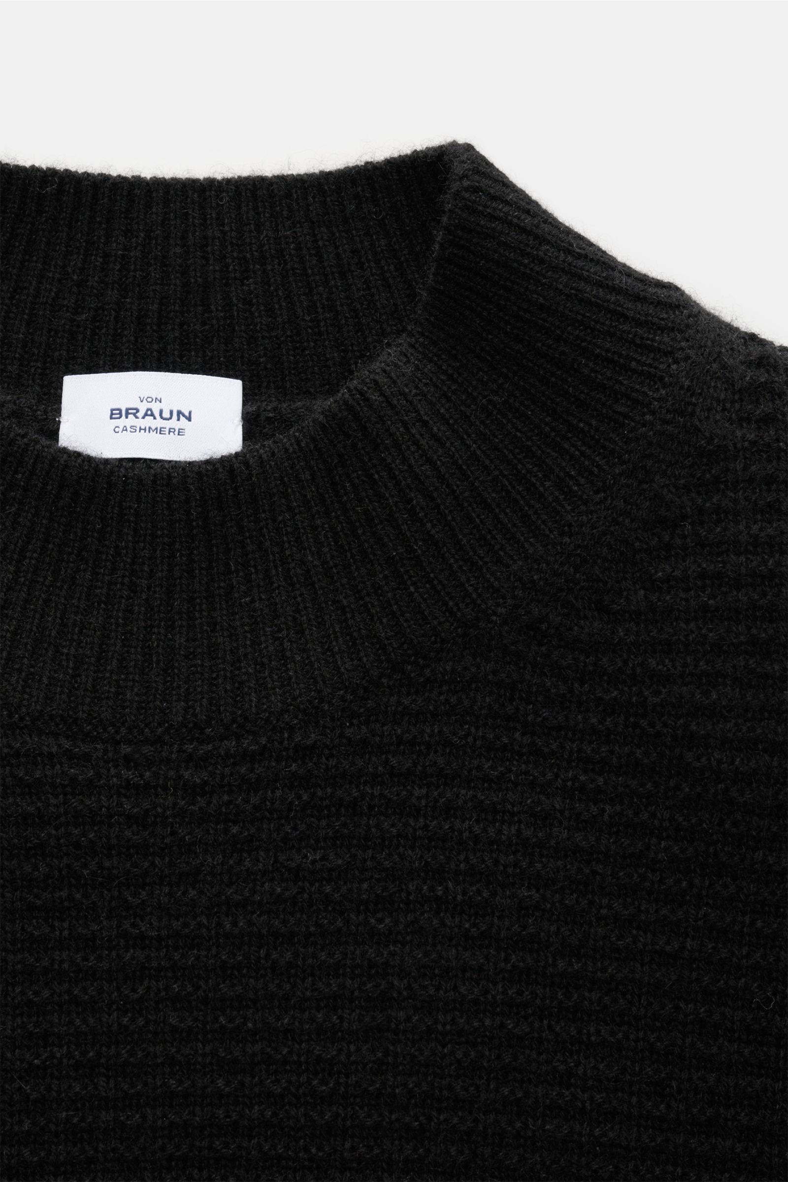 Close-up front view of von Braun Cashmere mock neck jumper black showing rib knit mock neck and fine textured knit fabric.

Get ready for the colder months with VON BRAUN: This jumper with mock neck in pure, Mongolian cashmere in an elegant textured kn