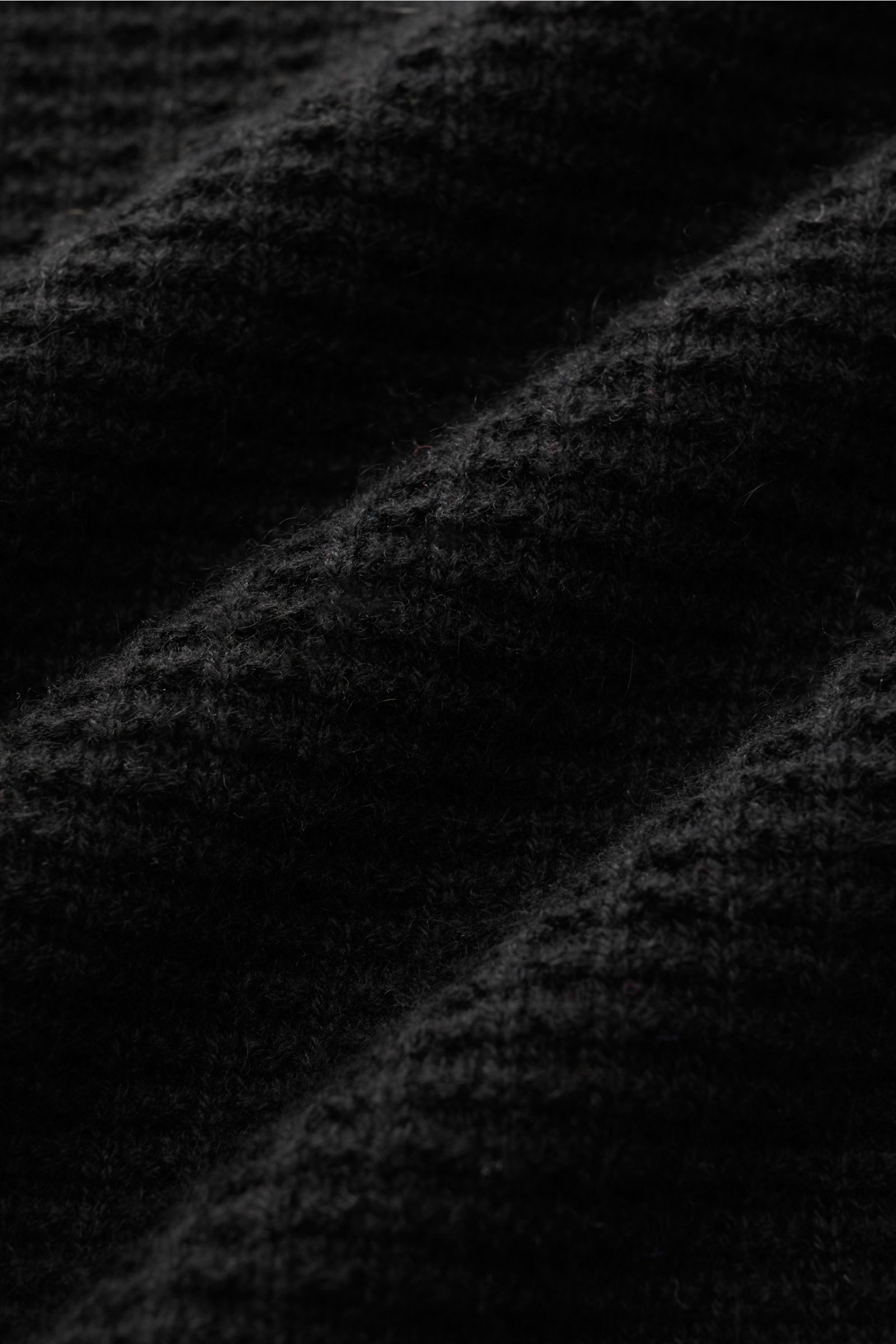 Close-up, angled top view of black von Braun Cashmere mock neck jumper showing fine textured, medium-fine knit in pure Mongolian cashmere with soft feel and ribbed bands. 

Get ready for the colder months with VON BRAUN: This jumper with mock neck in p