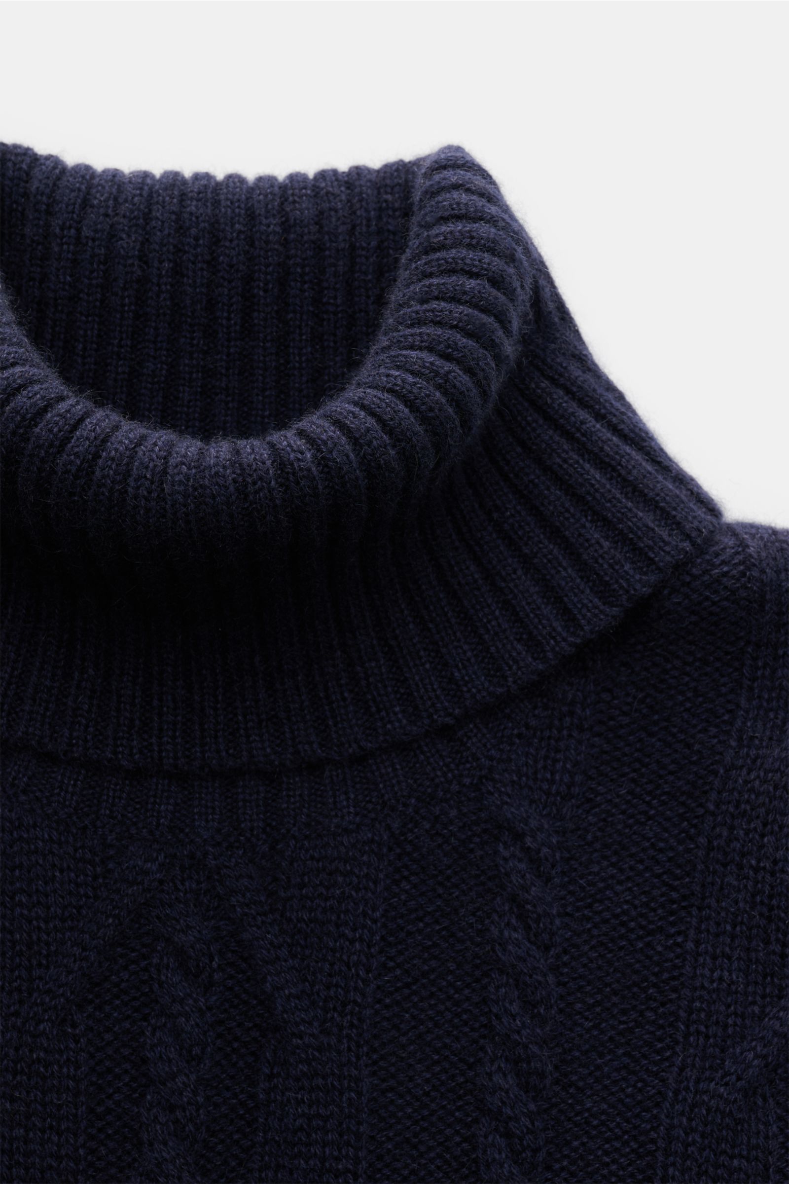 Nahaufnahme von von Braun Cashmere Rollkragenpullover navy, seitliche Perspektive zeigt anliegenden Rollkragen und zeitloses Zopfstrickmuster.