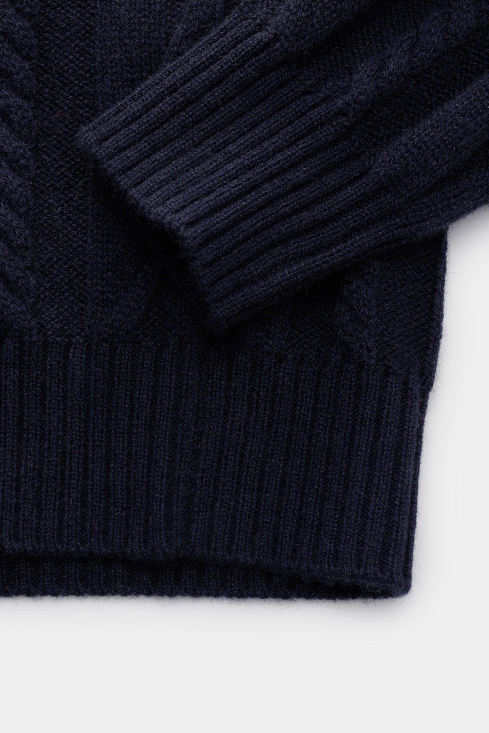 Nahaufnahme des von Braun Cashmere Rollkragenpullover navy von unten, zeigt weiches, mittelfeines Zopfstrickmuster, Slim Fit, Rippbündchen.