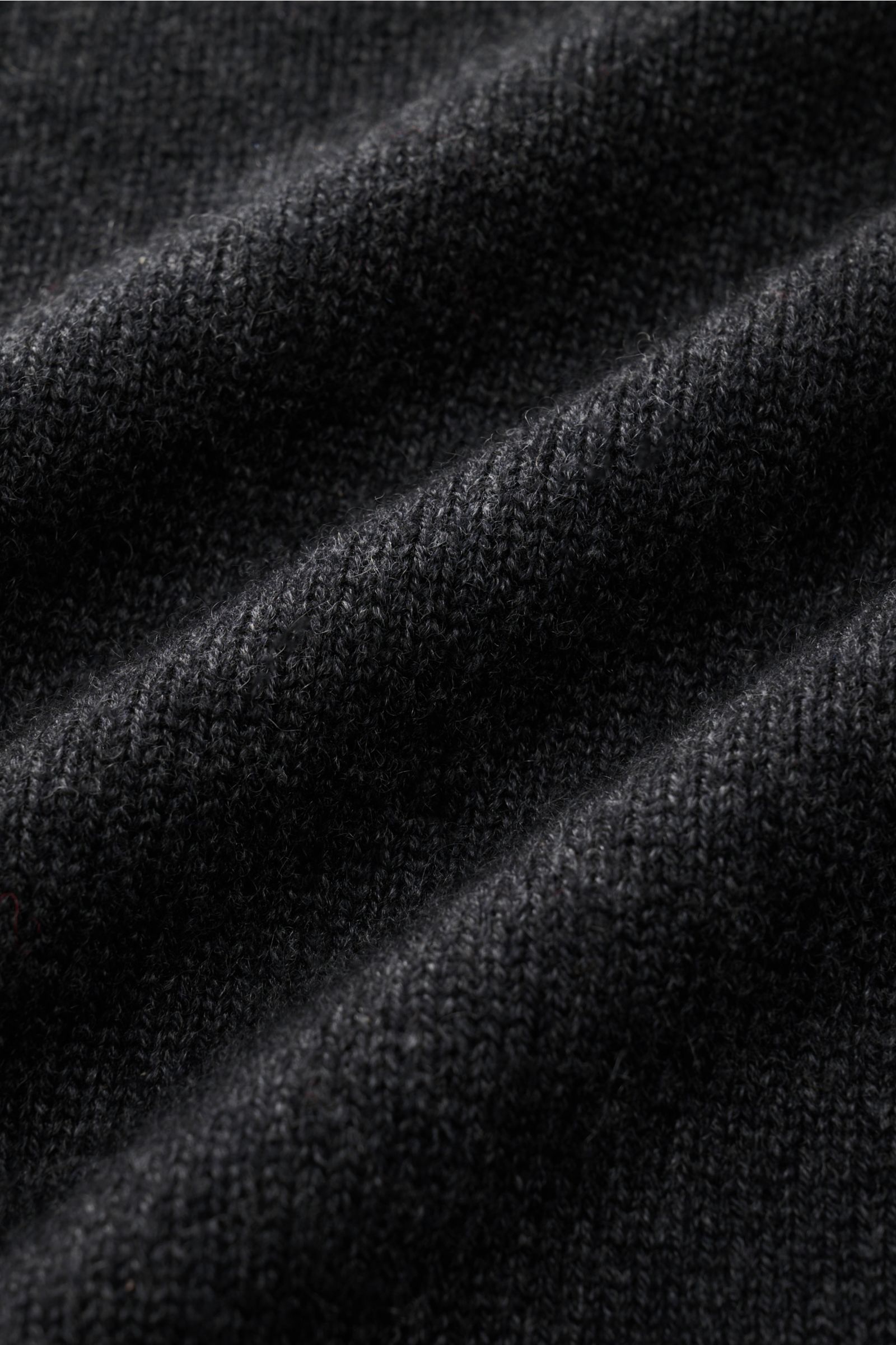 Nahaufnahme des von Braun Cashmere Rollkragenpullovers anthrazit meliert, mittelfeines Strickbild, weicher Griff, aus reiner Mongolei-Cashmere-Qualität.