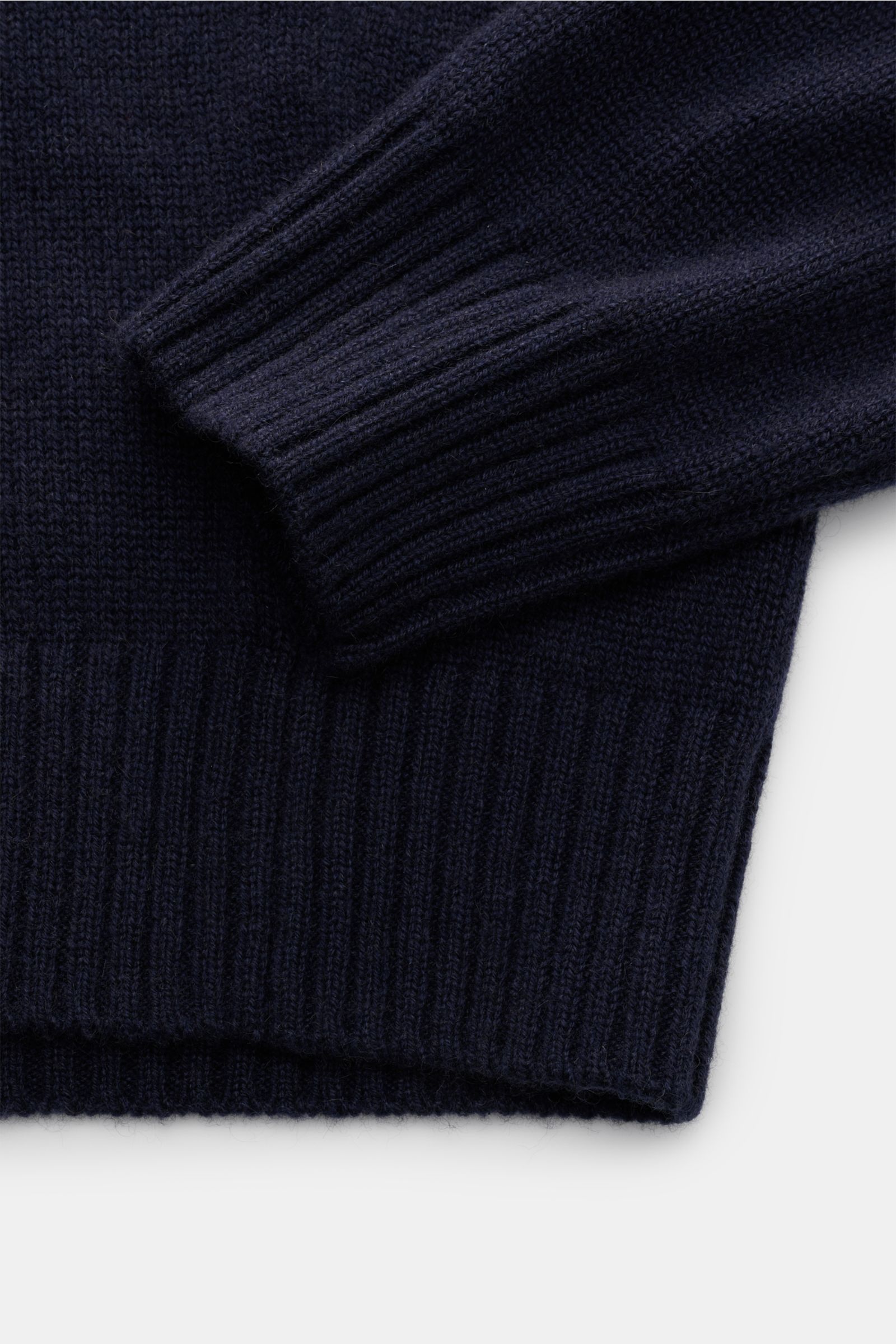 Nahaufnahme des von Braun Cashmere Rollkragenpullovers navy, fotografiert von oben, zeigt weichen, mittelfeinen Strick, anliegenden Rollkragen und Rippbündchen.