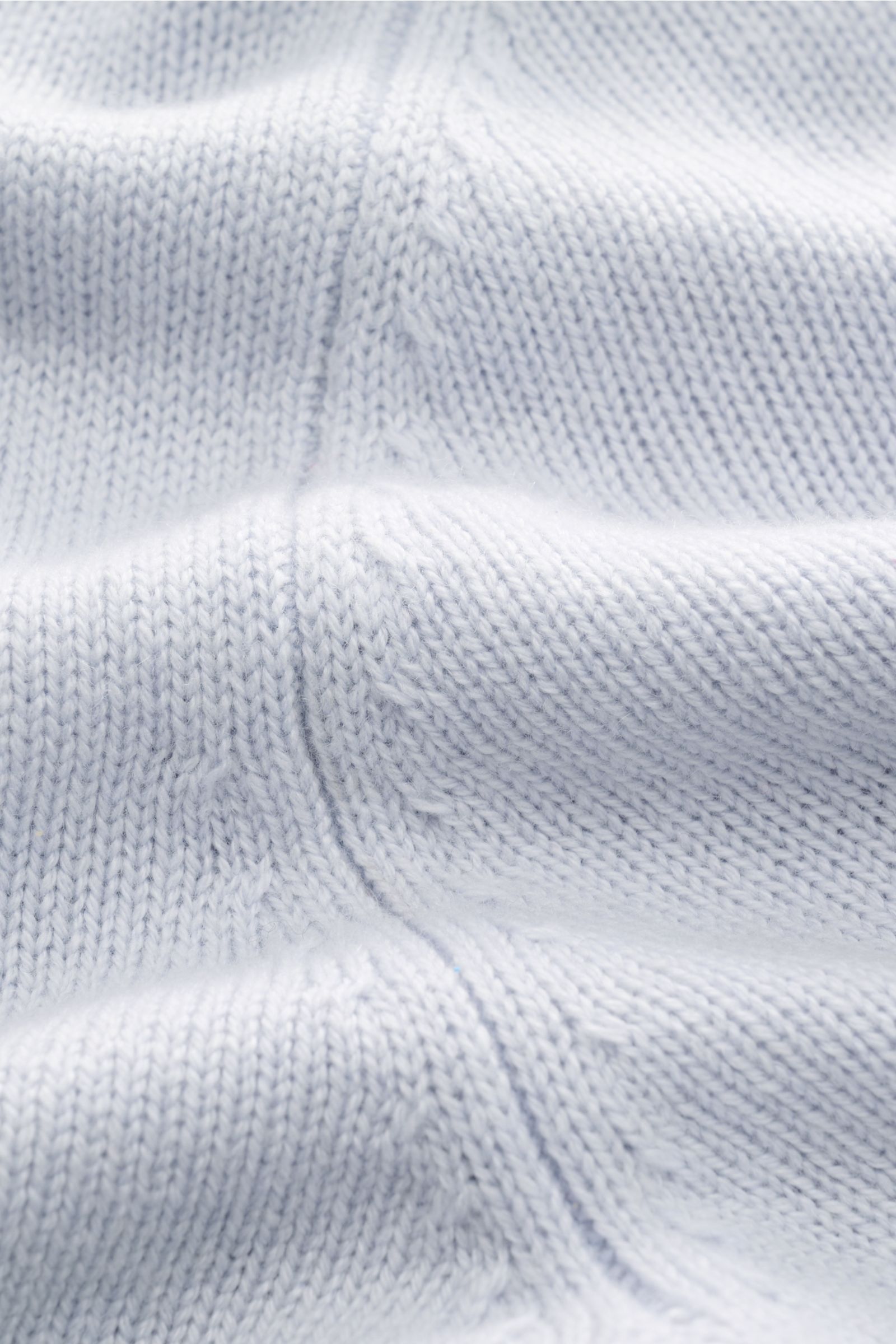 Nahaufnahme des von Braun Cashmere Rollkragenpullovers hellblau, mittelfeines Strickbild, weicher Griff, Regular Fit mit anliegendem Rollkragen und Rippbündchen.