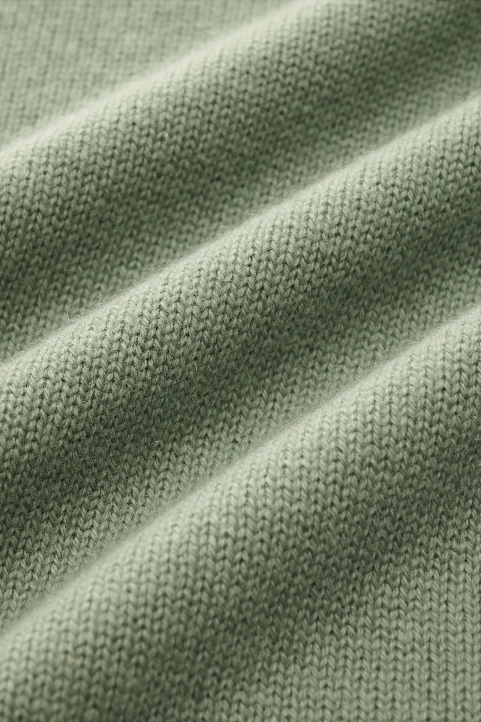 Nahaufnahme des mittelfeinen Strickbildes des graugrünen von Braun Cashmere Rollkragenpullovers aus weichem, reinem Cashmere.