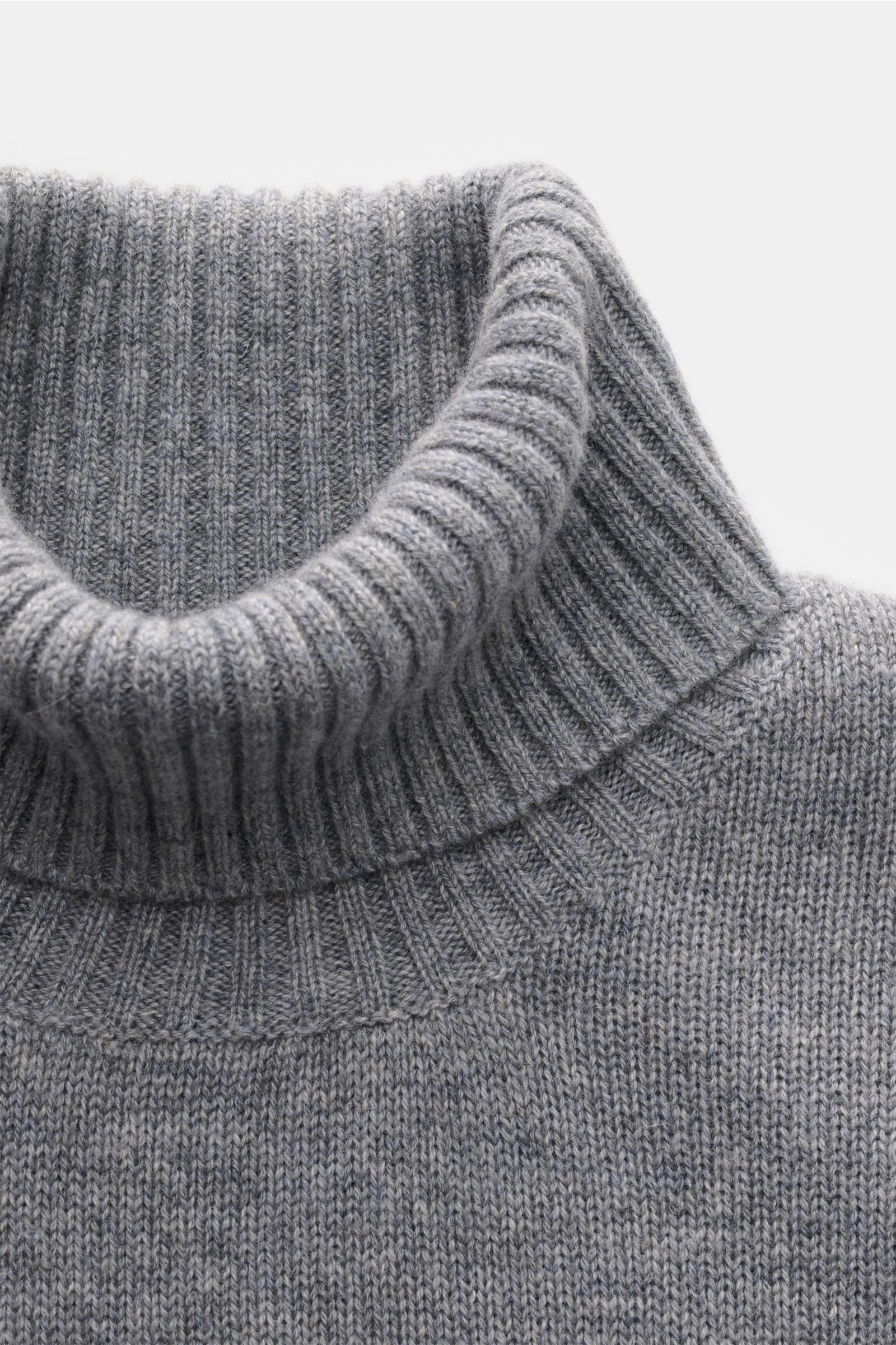 Nahaufnahme des von Braun Cashmere Rollkragenpullovers grau meliert von oben, mittelfein gestrickt mit anliegendem Rollkragen und Rippbündchen.