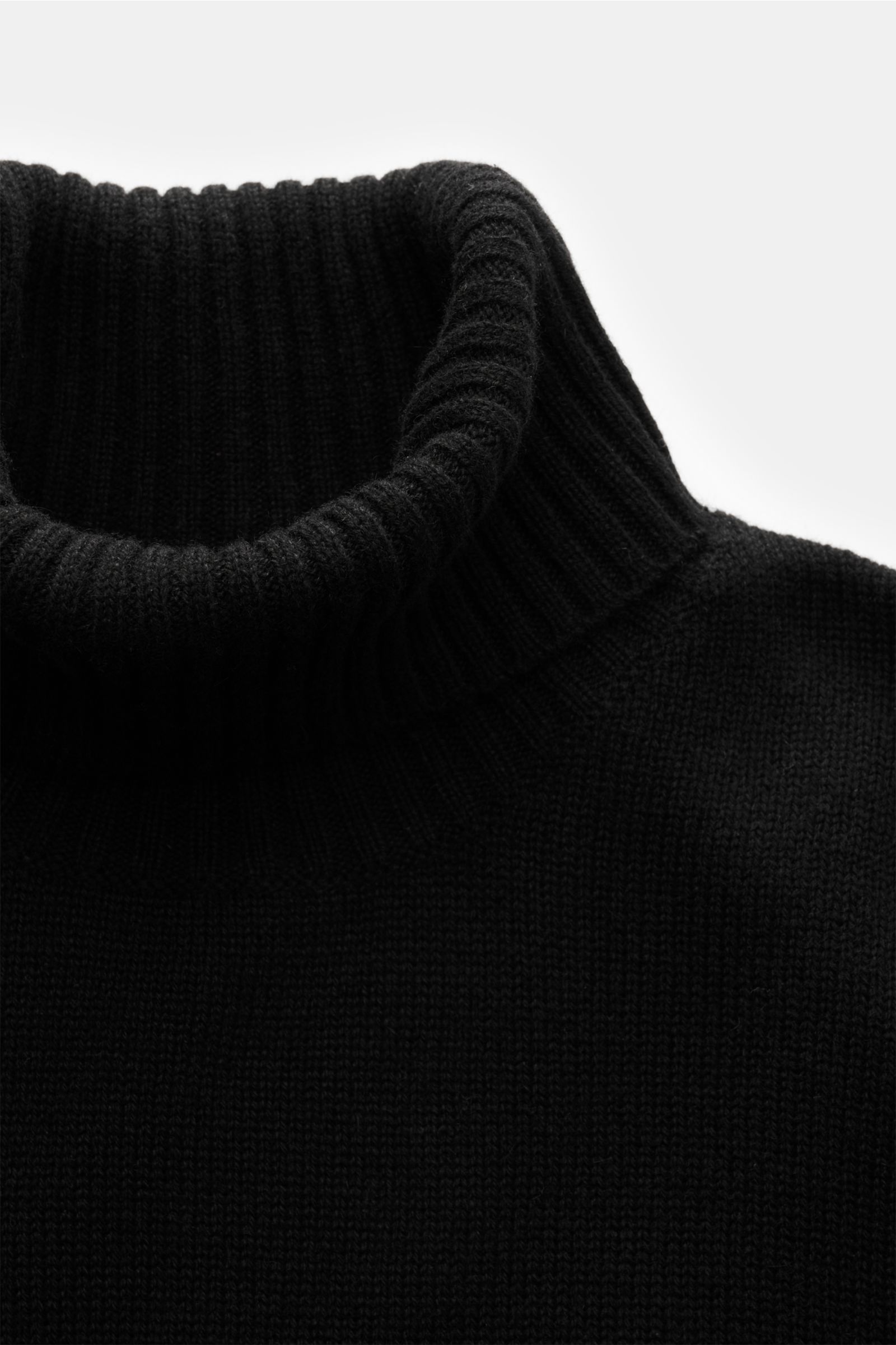 Nahaufnahme des von Braun Cashmere Rollkragenpullovers schwarz, fotografiert von oben, zeigt anliegenden Rollkragen und mittelfeines Strickbild, reiner Cashmere, Regular Fit, weicher Griff, komfortable Rippbündchen.