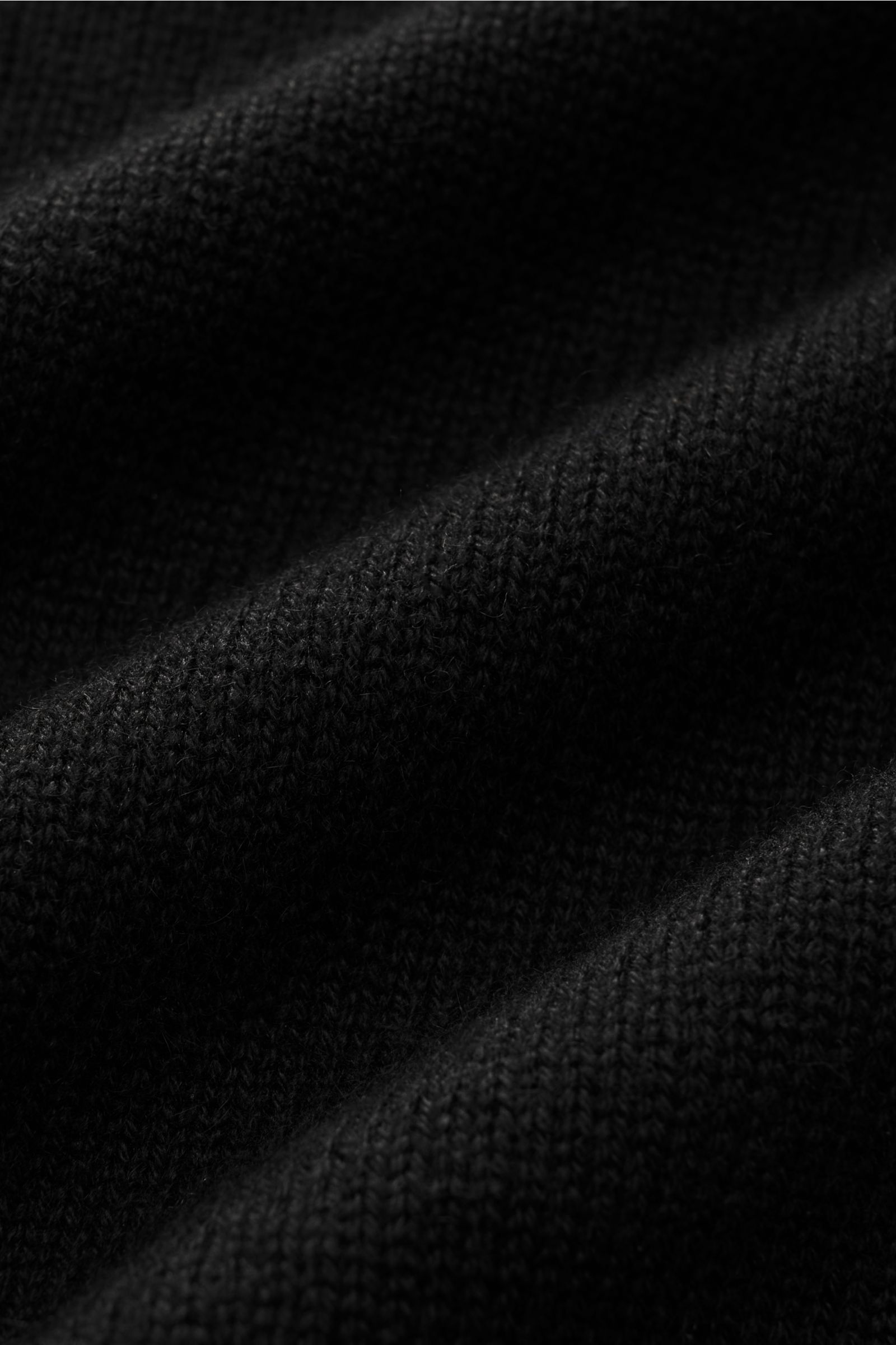 Nahaufnahme des von Braun Cashmere Rollkragenpullovers schwarz, mittelfeines Strickbild, weicher Griff, anliegender Rollkragen, Regular Fit.