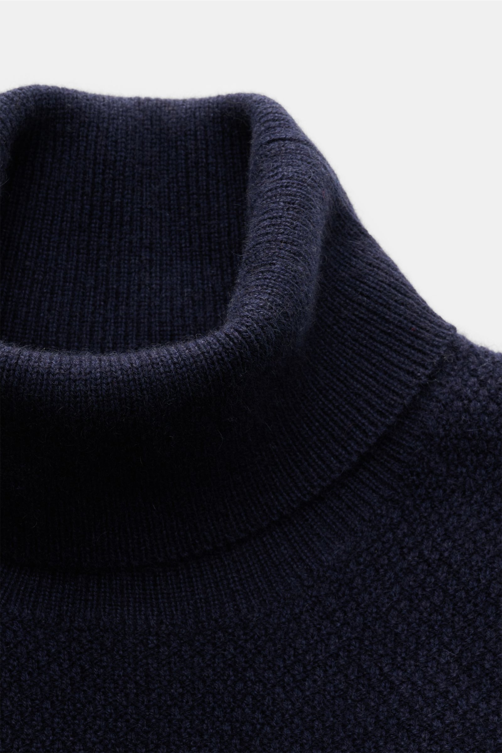 Nahaufnahme des von Braun Cashmere Rollkragenpullovers navy aus reinem mongolischem Cashmere, mittelfeiner Strukturstrick, Slim Fit, Rollkragen und Rippbündchen, seitliche Perspektive.