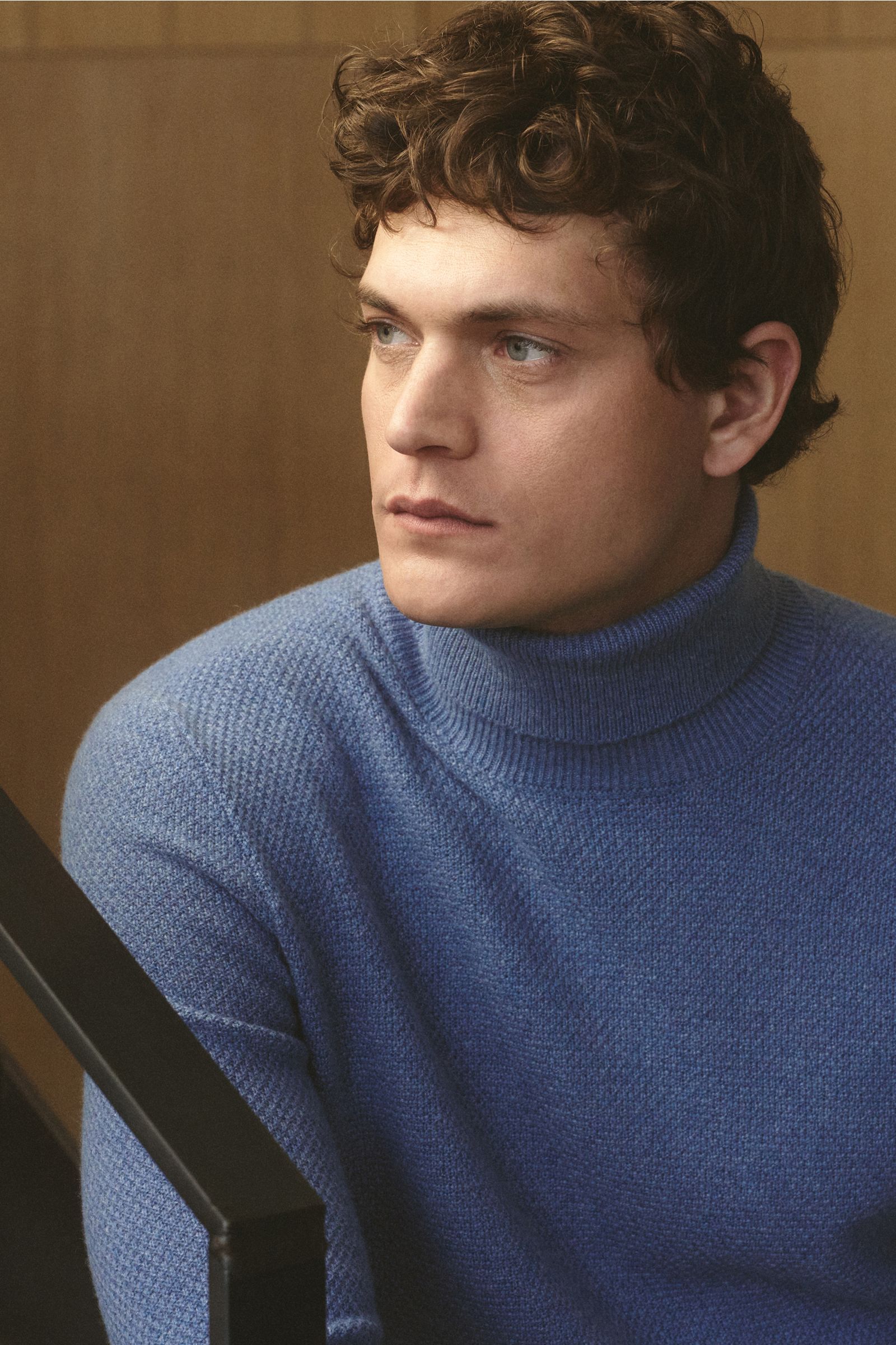 Mann im Halbprofil trägt von Braun Cashmere Rollkragenpullover blau meliert, Slim Fit, mongolischer Cashmere, Strukturstrick, Rippbündchen.