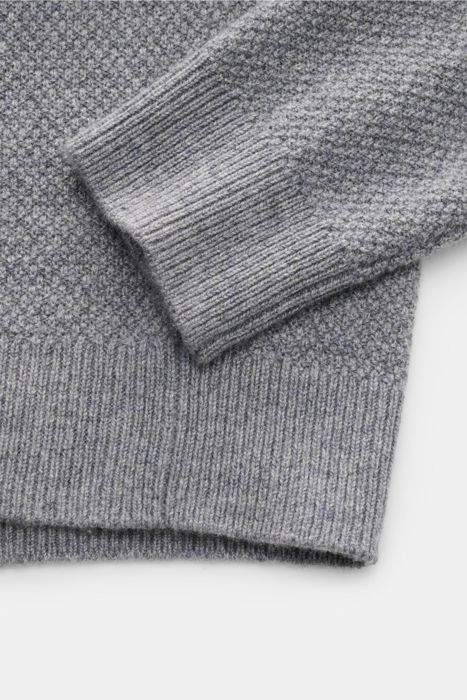 Close-up from above of the sleeve and hem of the von Braun Cashmere turtleneck jumper grey mottled in fine textured, medium-fine knit.

Description: Get ready for the colder months with VON BRAUN: This turtleneck jumper in pure, Mongolian cashmere in a