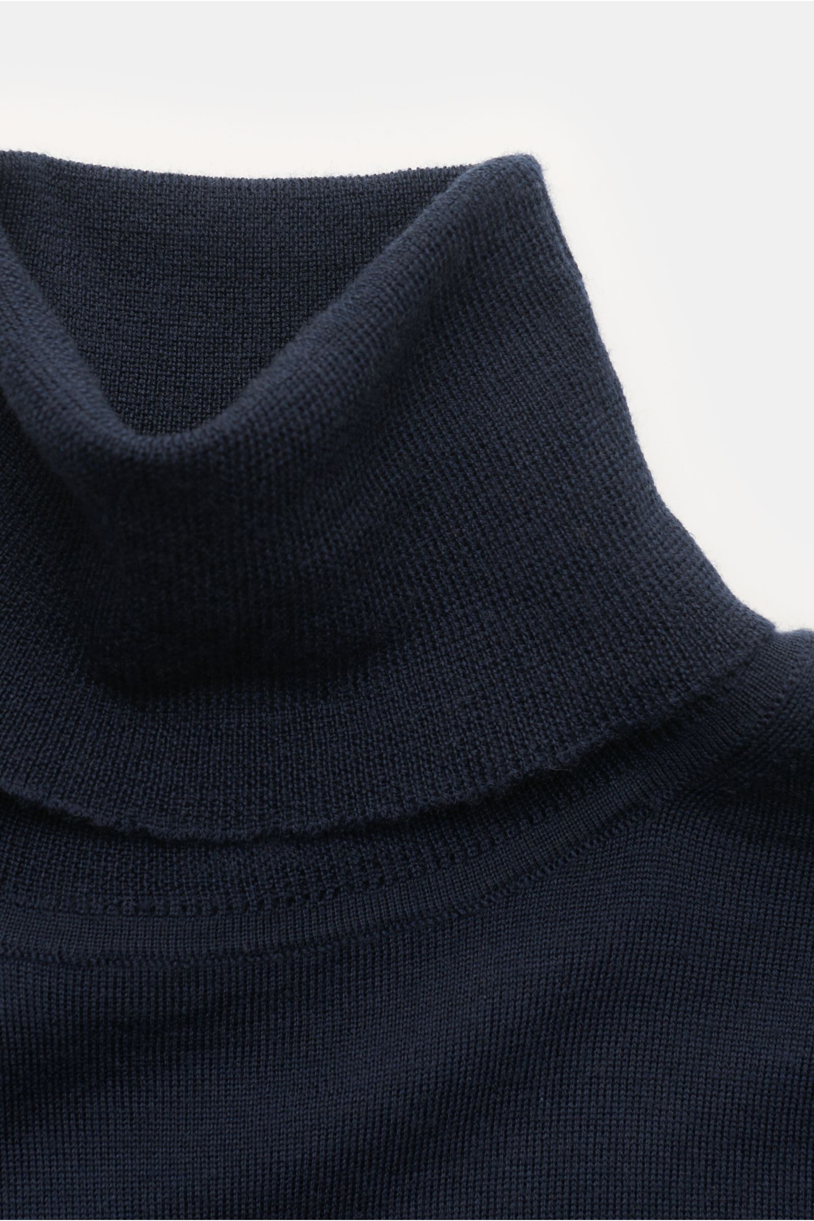 Nahaufnahme des von Braun Merino Rollkragenpullovers navy aus reiner Merinowolle mit feinem Strickbild, Slim Fit und flexiblem Rippkragen.