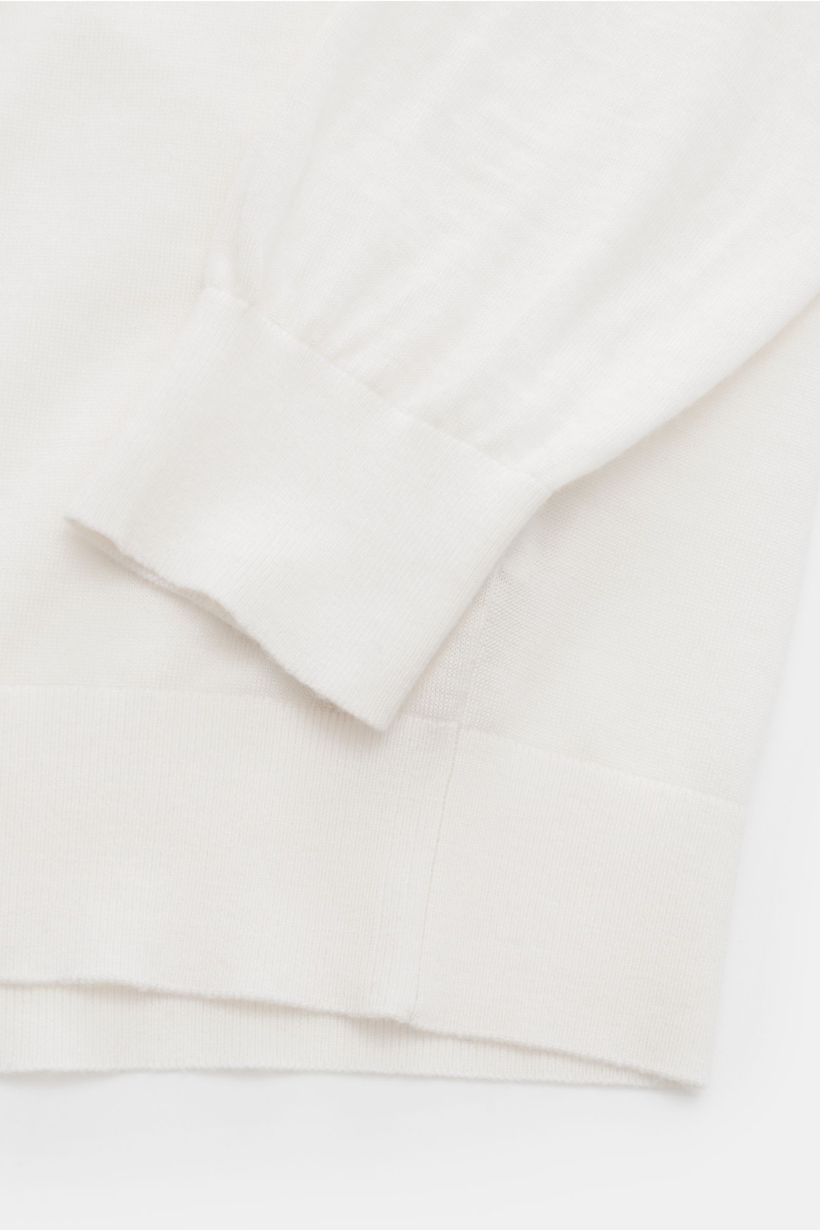 Nahaufnahme des von Braun Merino Rollkragenpullovers creme zeigt feines Strickbild, Slim Fit, Rollkragen und flexible Rippbündchen.