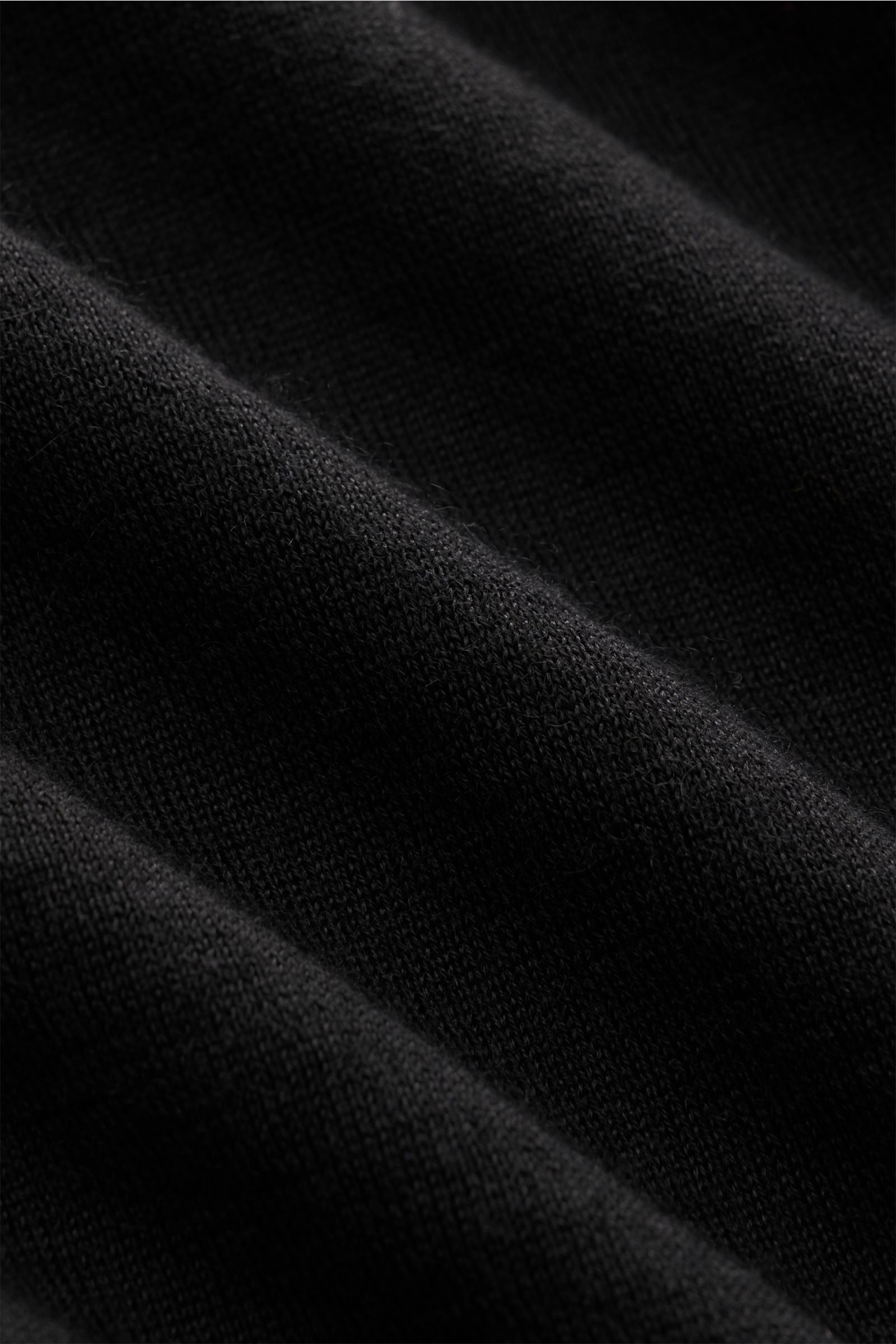 Nahaufnahme des schwarzen Colombo Feinstrick-Rollkragenpullovers, zeigt feines Strickbild, weichen Cashmere-Seiden-Mix und flexible Rippbündchen.