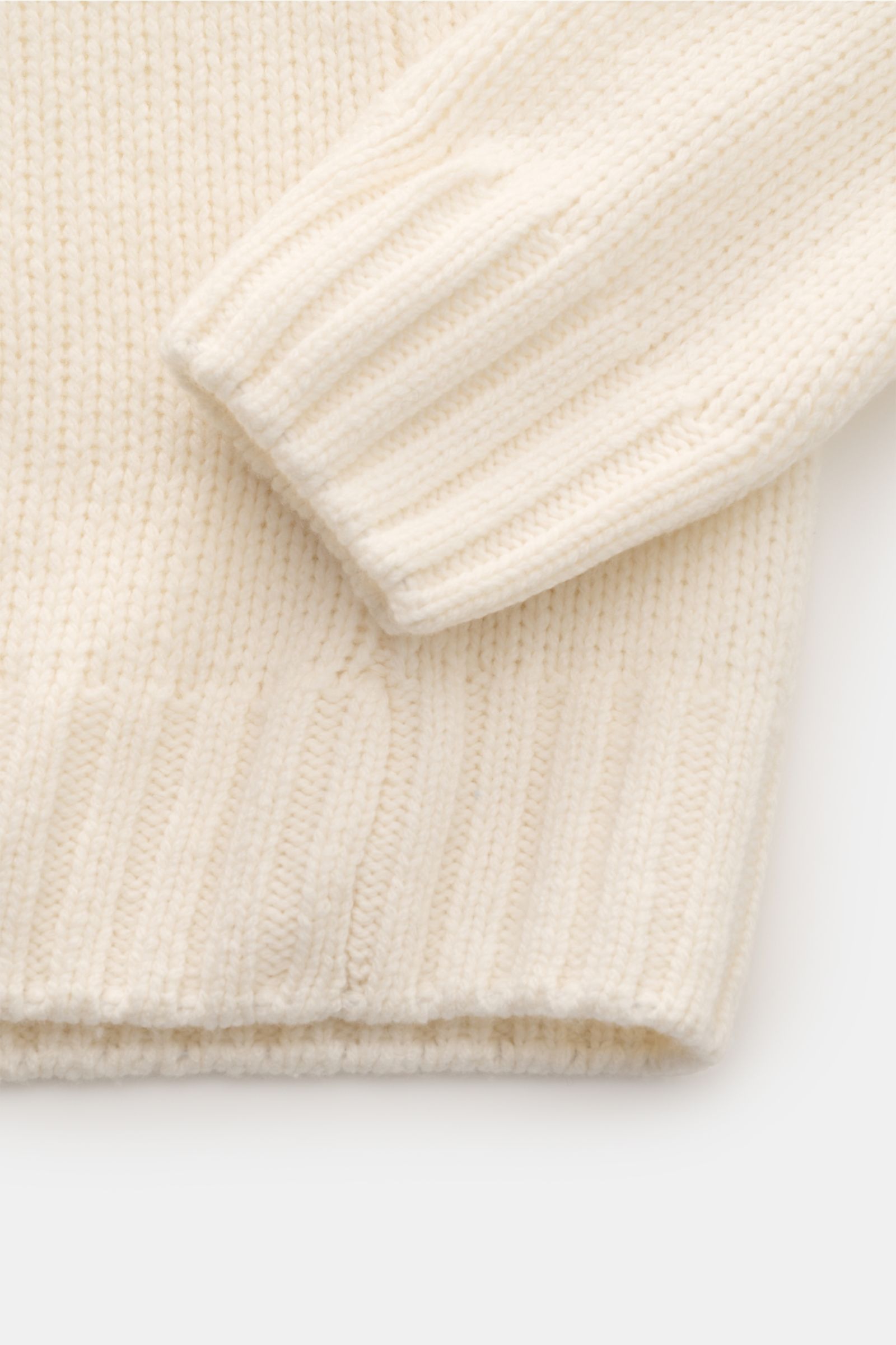 Nahaufnahme des 04651/ A trip in a bag Cashmere Rollkragenpullovers creme, von oben fotografiert, grobes Strickbild, weiche Rippsäume, Oversized Fit.