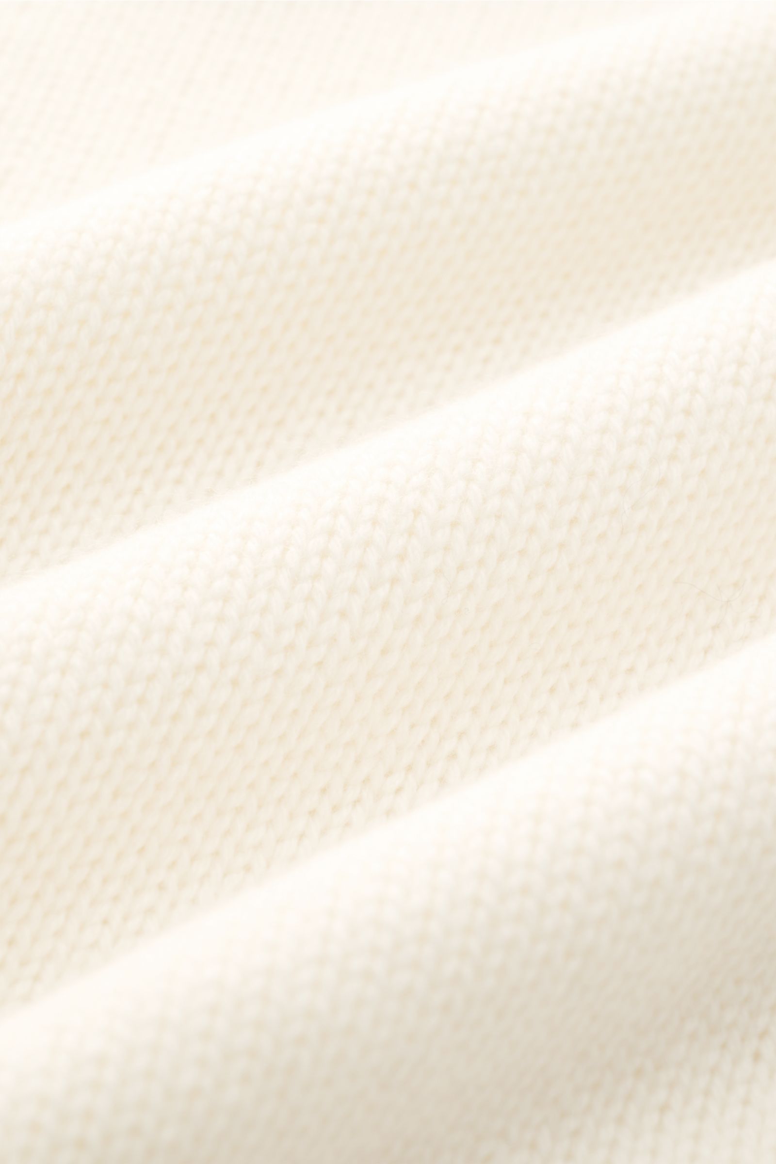Close-up detail of the cream-colored Fioroni Cashmere Rundhalspullover creme fabric, showing the fine knit texture from a top-down perspective.

Description: Souveräne Eleganz in ihrer luxuriösesten Form: Der Rollkragenpullover von FIORONI aus erlesene