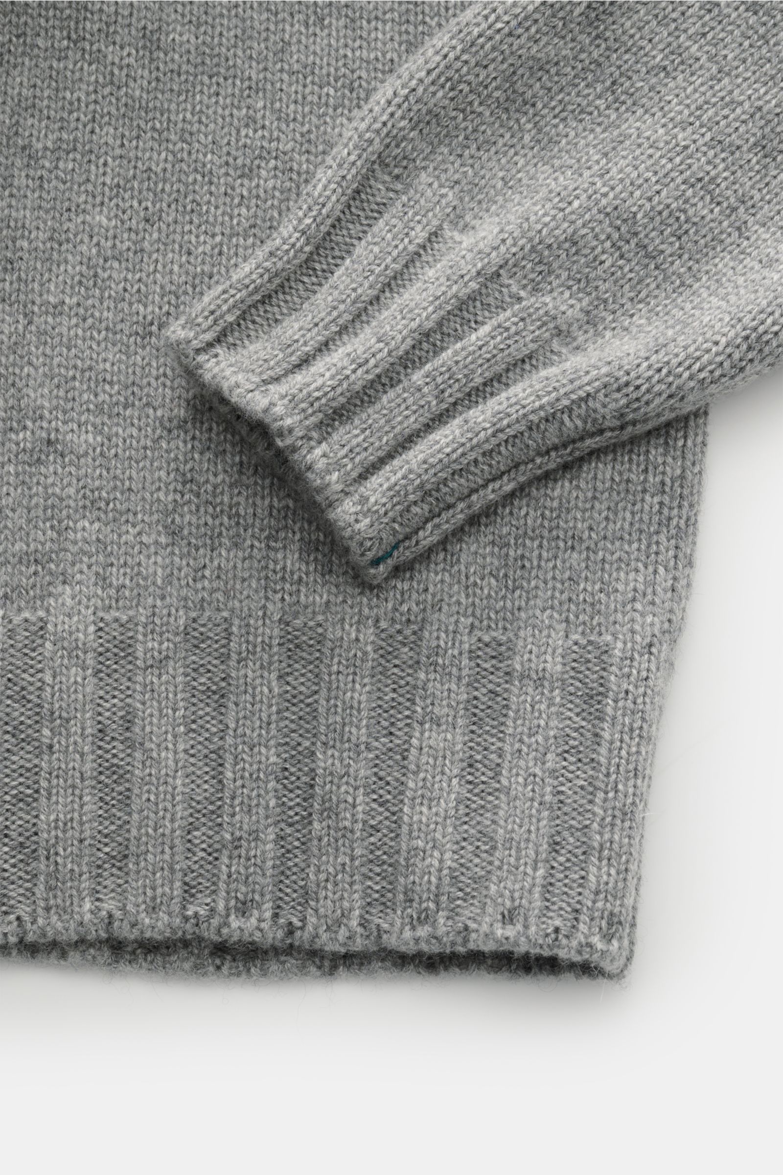 Close-up view of the sleeve and hem of the Fioroni Cashmere Rundhalspullover dunkelgrau meliert, showcasing fine mid-weight knit and flexible ribbed cuffs.

Souveräne Eleganz in ihrer luxuriösesten Form: Der Rollkragenpullover von FIORONI aus erlesenem