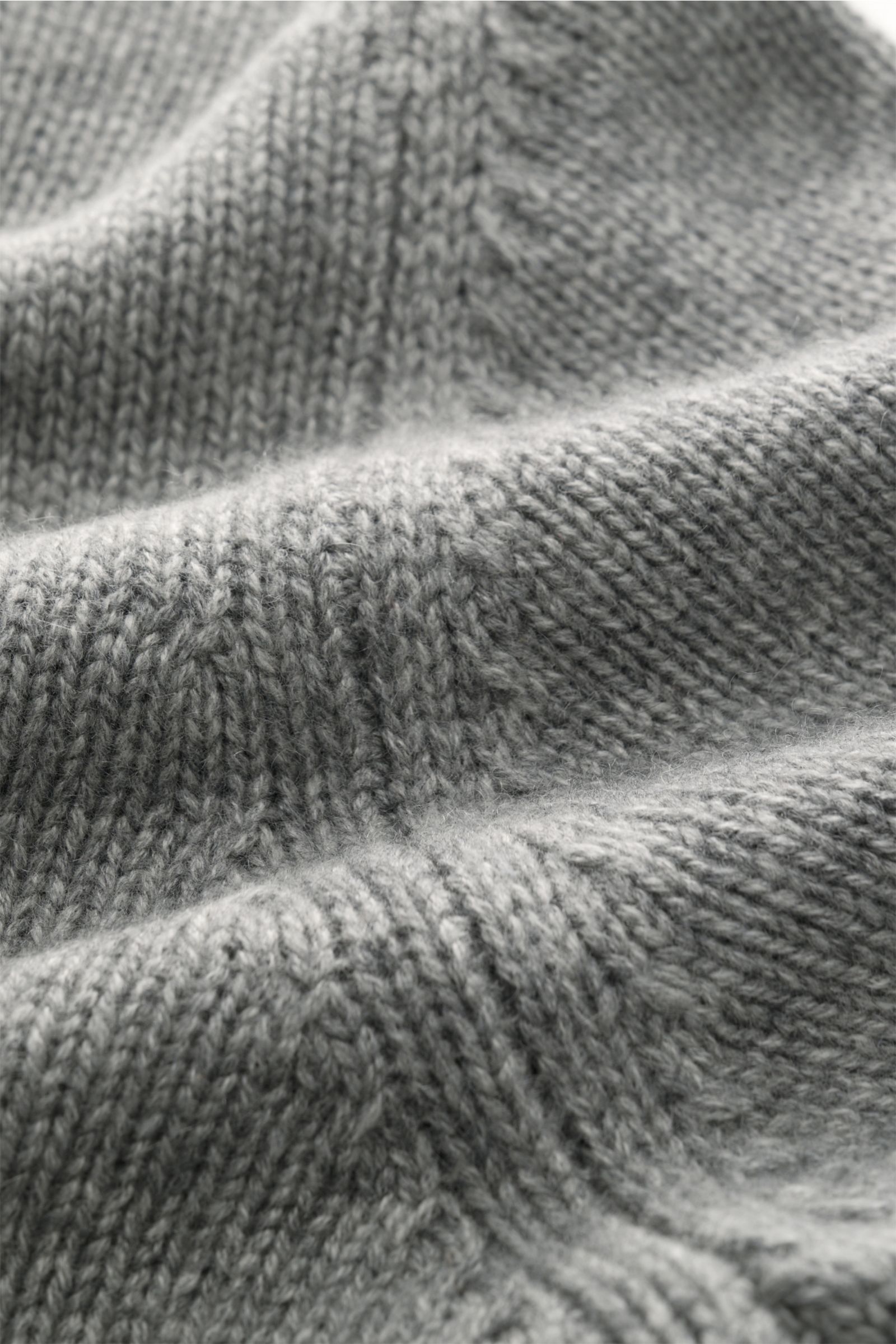 Close-up view of the Fioroni Cashmere Rundhalspullover dunkelgrau meliert, showcasing its fine mid-knit texture and soft fibers from an angled perspective. Souveräne Eleganz in ihrer luxuriösesten Form: Der Rollkragenpullover von FIORONI aus erlesenem 
