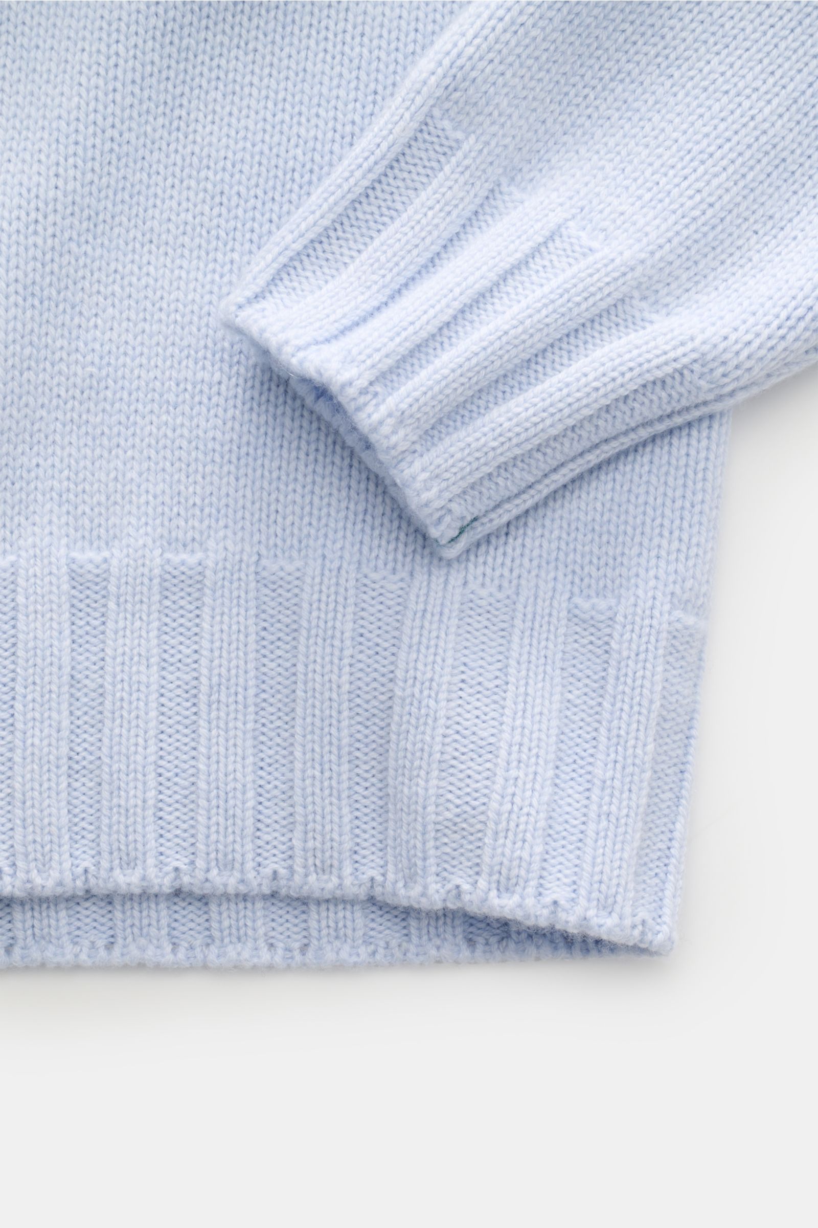 Close-up view of the sleeve and bottom hem of the Fioroni Cashmere Rundhalspullover graubraun meliert, showcasing its flexible ribbed cuffs and medium-fine knit texture.

Souveräne Eleganz in ihrer luxuriösesten Form: Der Rollkragenpullover von FIORONI