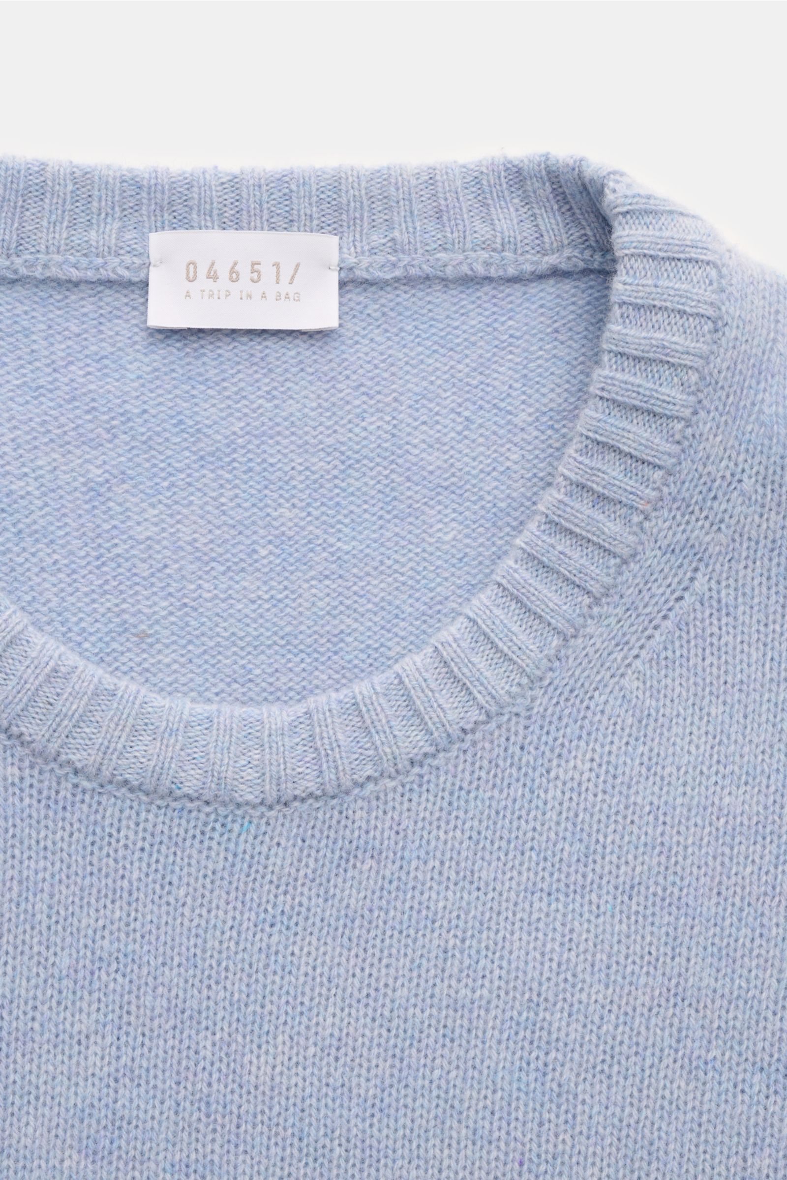 Nahaufnahme des hellblau melierten 04651/ A trip in a bag Cashmere Rundhalspullover Slim Fit mit reinem Cashmere, sehr weichem Griff, hochwertiger Fully-Fashioned-Machart, feinem Strickbild und elastischen Rippbündchen am Rundhalsausschnitt.