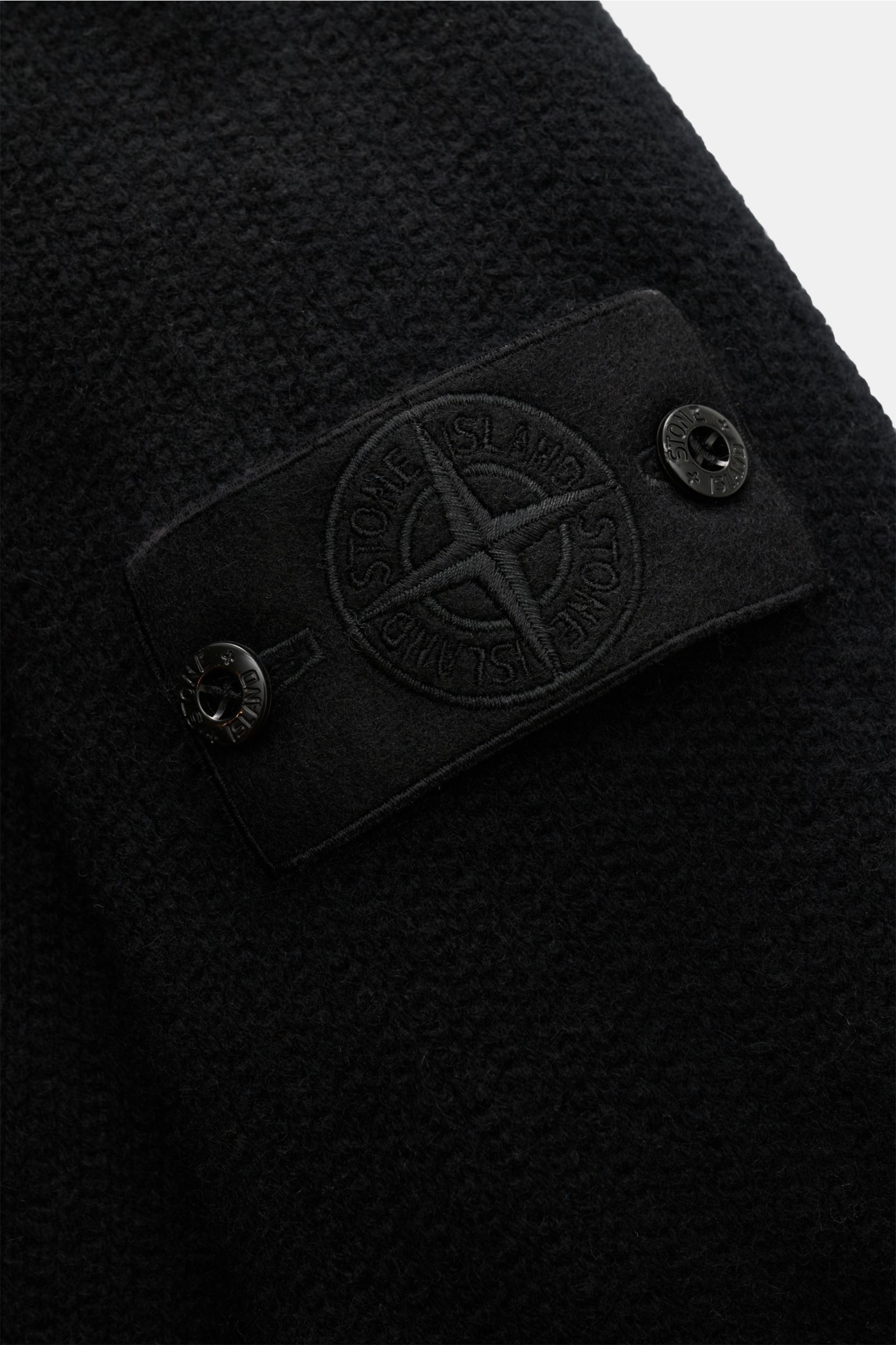Stone Island Cashmere Rundhalspullover 'Ghost' schwarz, Detailansicht des Kompass-Badges auf weichem, mittelfeinem Strick mit Rippbündchen.