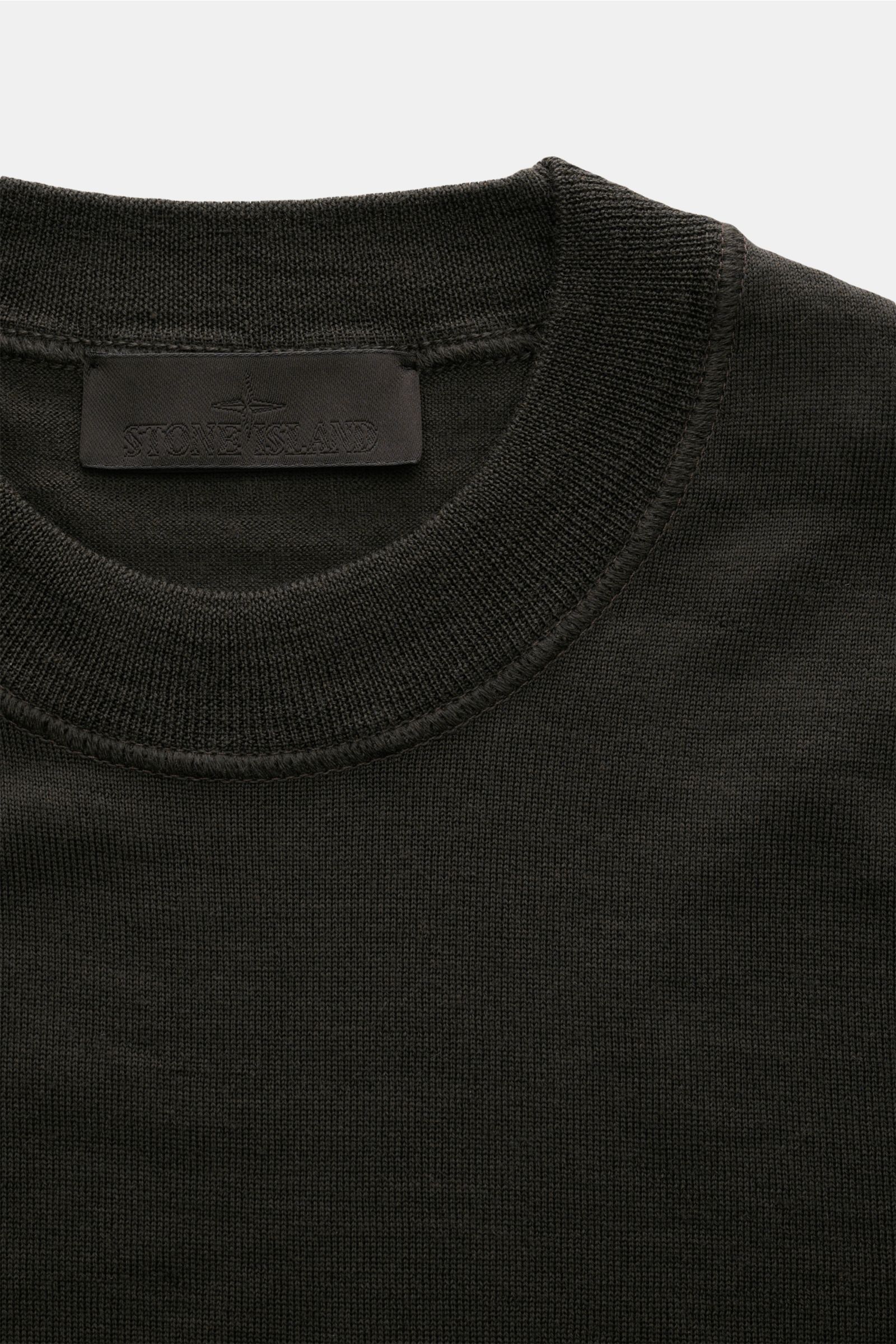 Stone Island Rundhalspullover 'Ghost Piece' dunkelbraun, Slim Fit, Rundhalsausschnitt, reine Wolle, feines Strickbild, tonales Kompass-Badge, Detailfoto von oben.