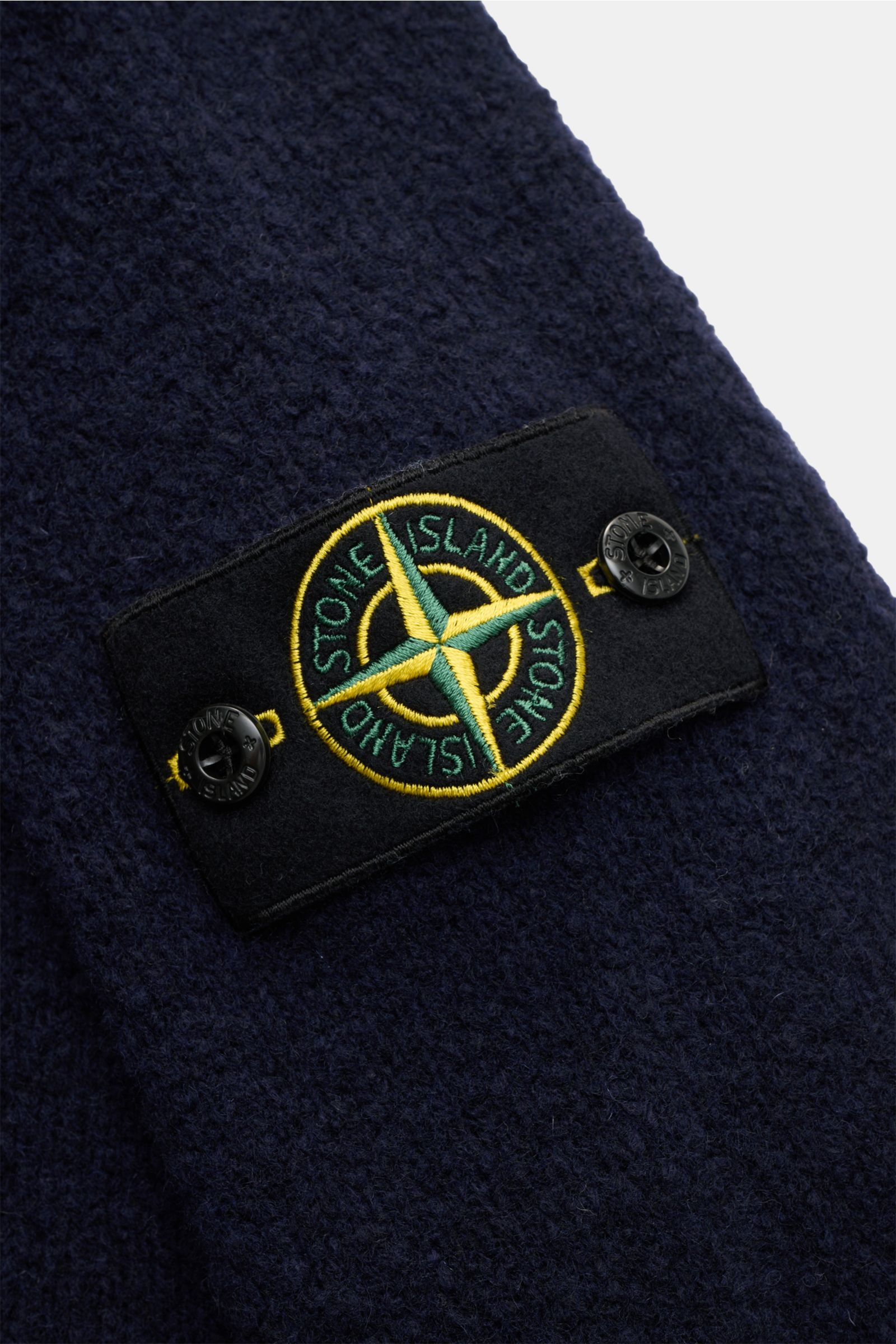 Nahaufnahme des Stone Island Rundhalspullover 'Fancy Yarn' navy in Bouclé-Strick mit markentypischem Kompass-Badge am Oberarm, weicher Griff.