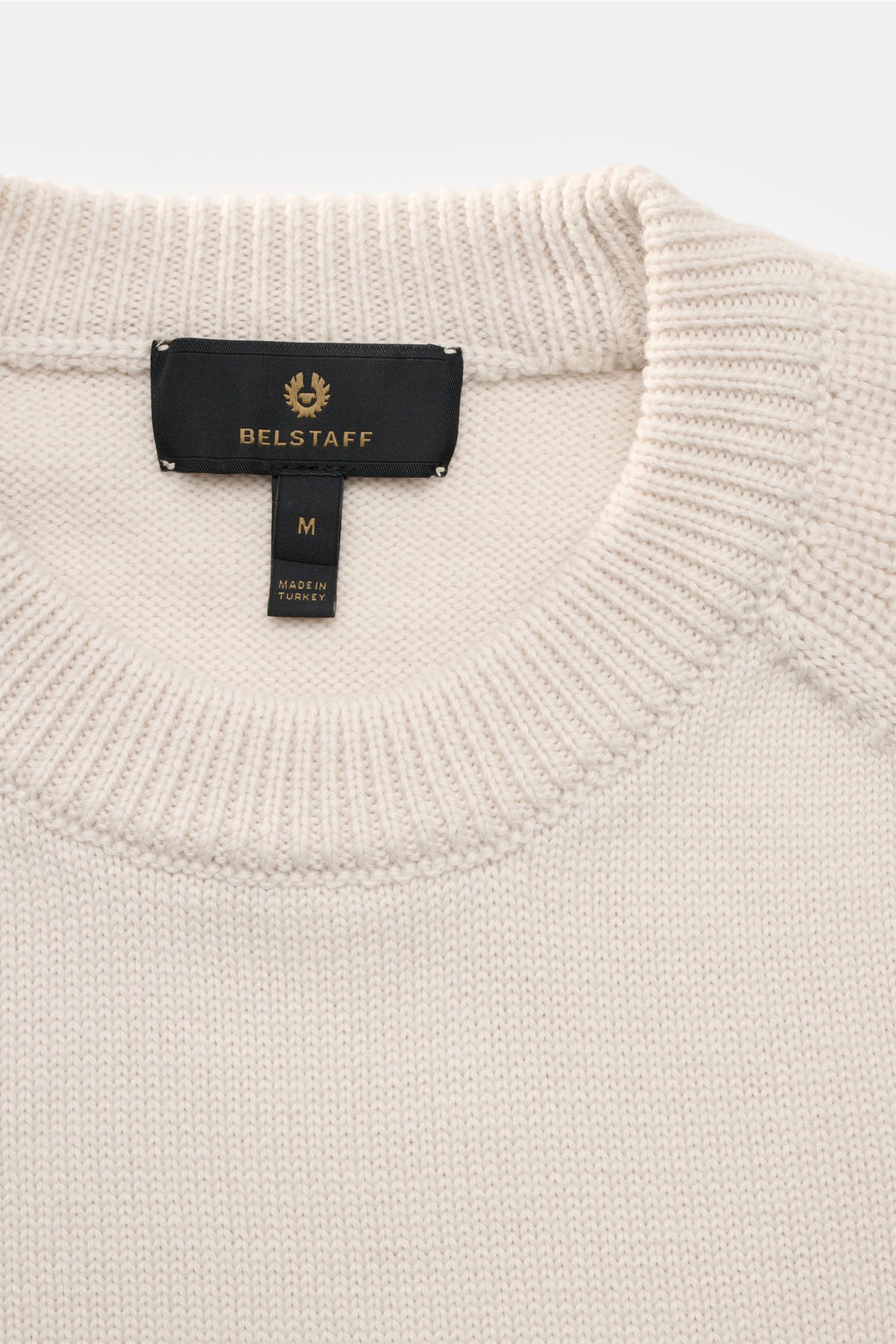 Close-up front view of Belstaff Rundhalspullover 'Aspect' sand, a versatile classic for fall and winter made of pure wool with soft feel, medium-fine knit, regular fit, crew neck, Belstaff label on upper arm, raglan sleeves, and comfortable ribbed cuffs. 