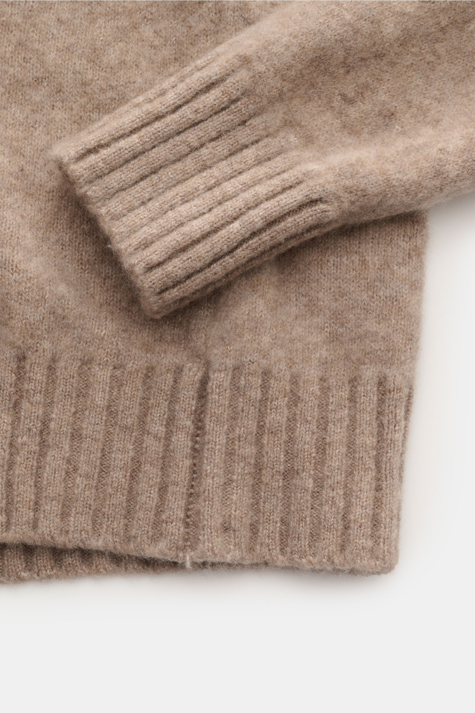 Close-up view of the Piacenza 1733 Rundhalspullover beige sleeve and hem, showing soft, medium-fine knit with ribbed cuffs.

Description: Der wohl softeste Rundhalspullover der Saison kommt aus der italienischen Spinnerei PIACENZA – das zeitlose Modell