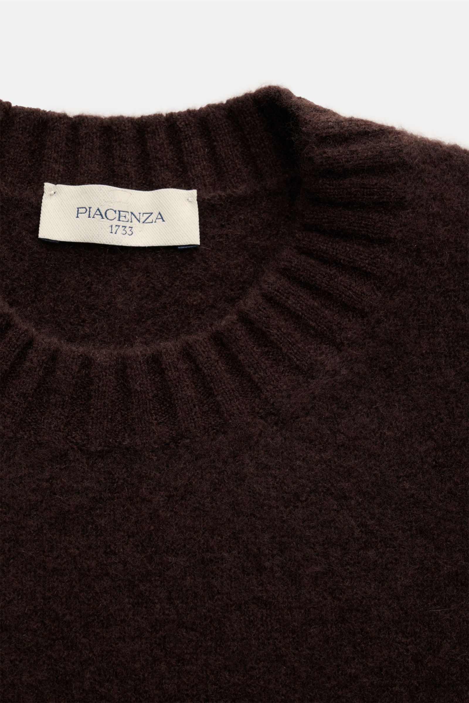 Piacenza 1733 Rundhalspullover dunkelbraun shown from a top close-up view, featuring a soft cashmere, silk, and microfiber blend with ribbed round neckline and label.