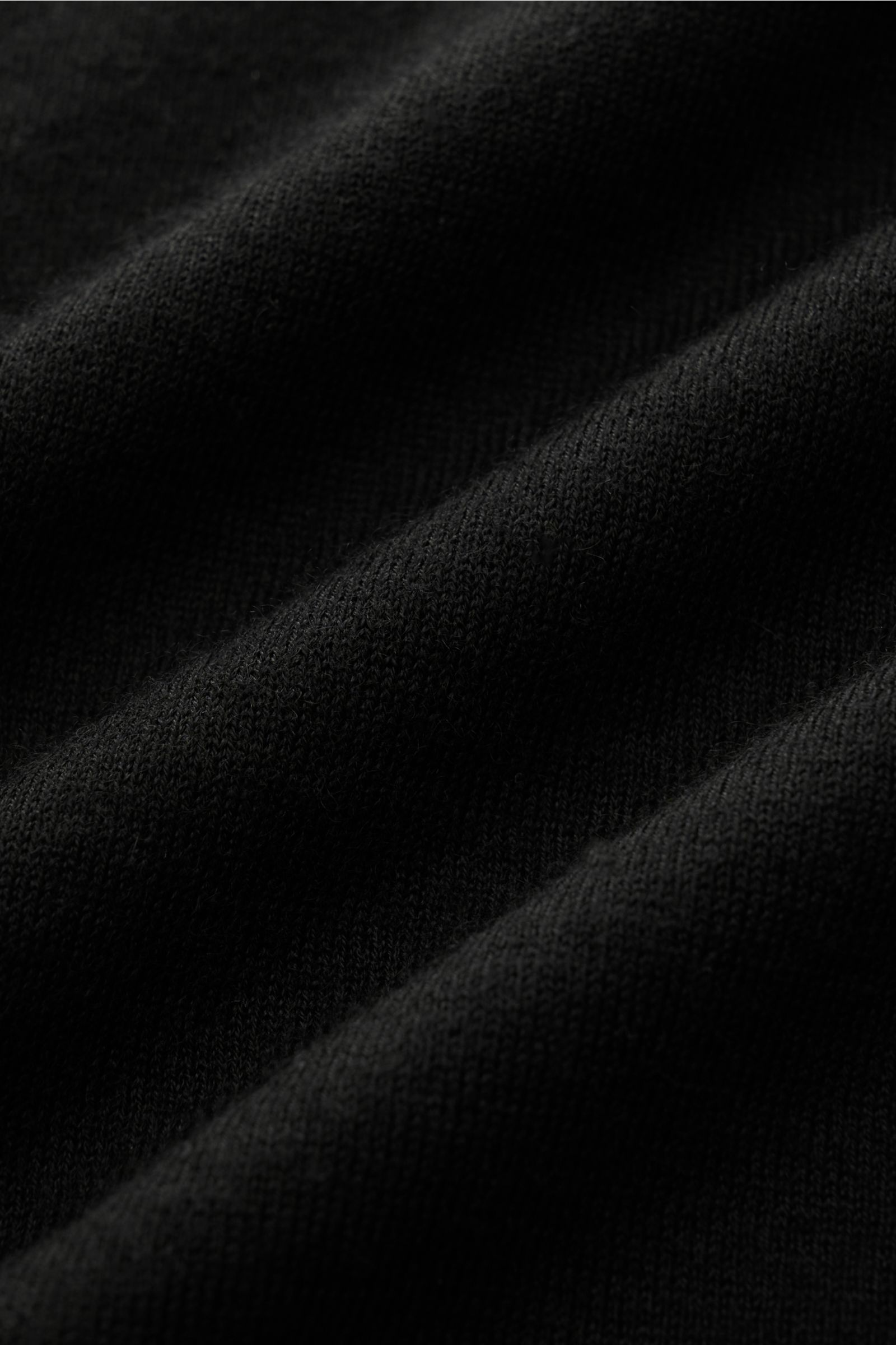 Close-up of the fine knit texture of the Lisa Yang Cashmere V-Neck Kurzarm-Pullover 'Joakim' schwarz, photographed from a side angle showing soft folds.

Das feine Strickbild und der klassische Regular Fit des Cashmere Kurzarm-Pullovers 'Joakim' von LI