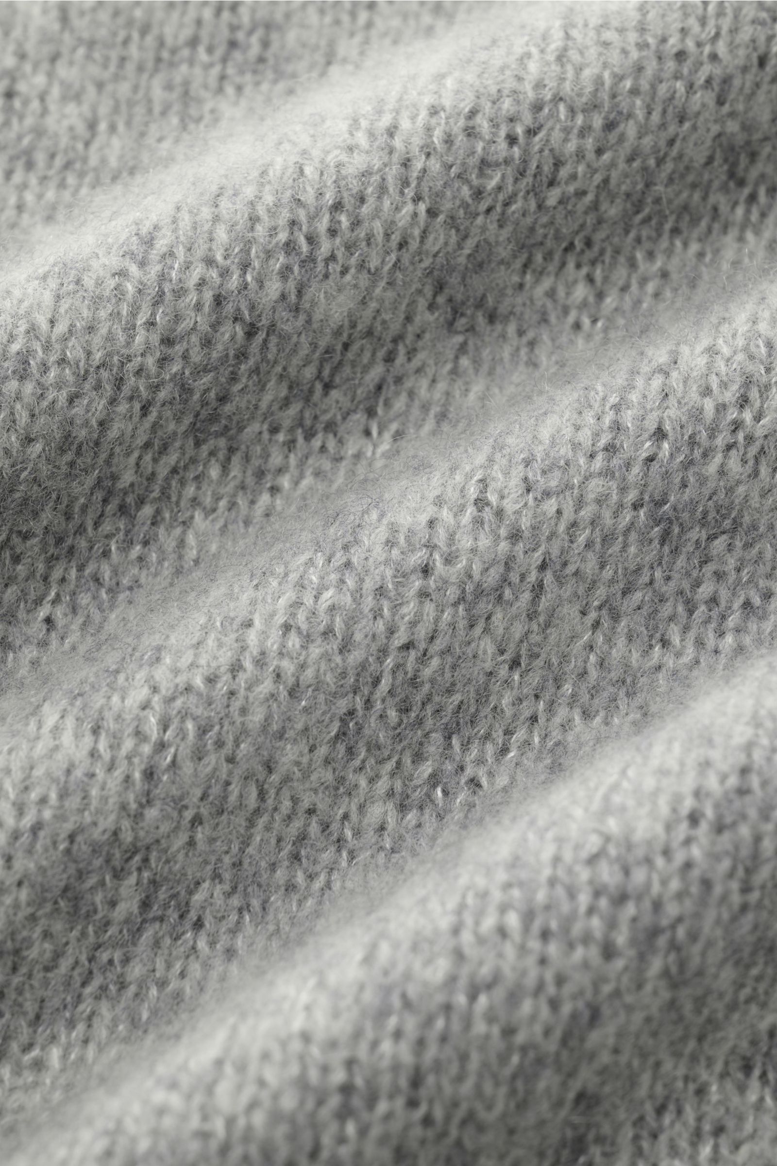 Nahaufnahme des fein gestrickten Materials vom Lisa Yang Rundhalspullover 'Baxter' grau meliert mit voluminöser Oberfläche und weichem Griff aus Cashmere und Seide.