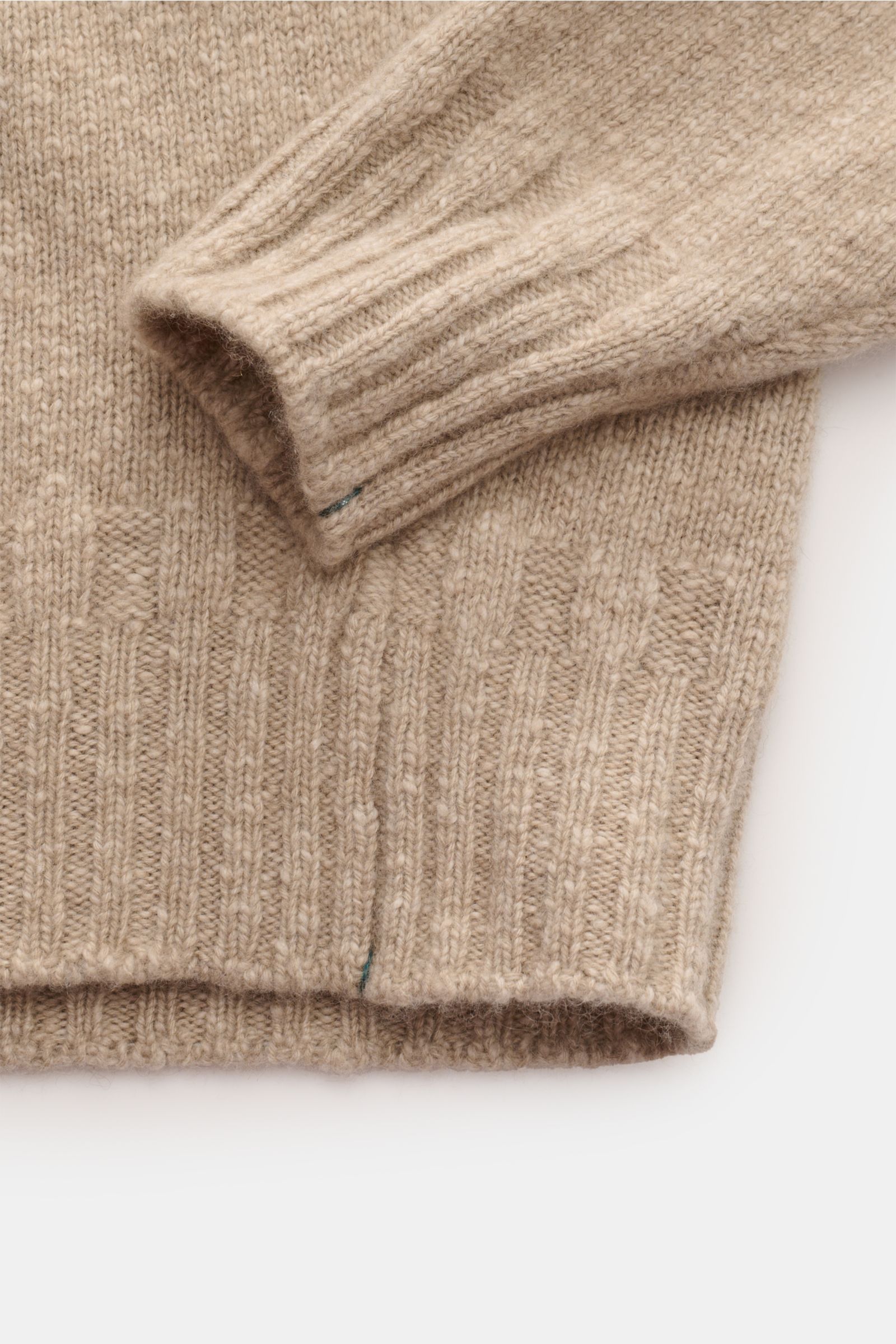 Close-up view of the sleeve and hem of the Fioroni Cashmere Rundhalspullover beige meliert, featuring reiner Cashmere, weicher Griff, mittelfeines Strickbild, leichter Bouclé-Effekt, Slim Fit, anliegender Rundhalsausschnitt, Raglan-Ärmel, and flexible Rip