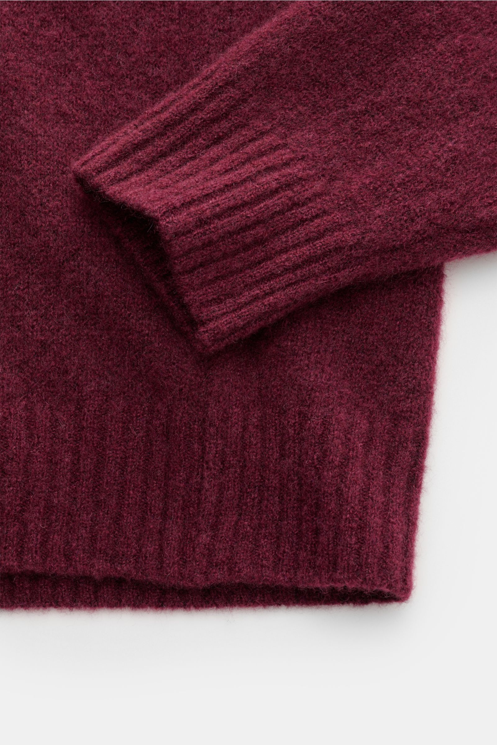 Close-up image of the sleeve and hem of the Filippo de Laurentiis Rundhalspullover bordeaux, photographed from above, showing a mix of cashmere, silk, and high-quality microfiber, very soft, voluminous feel, medium-fine knit pattern, slim fit, round neckl