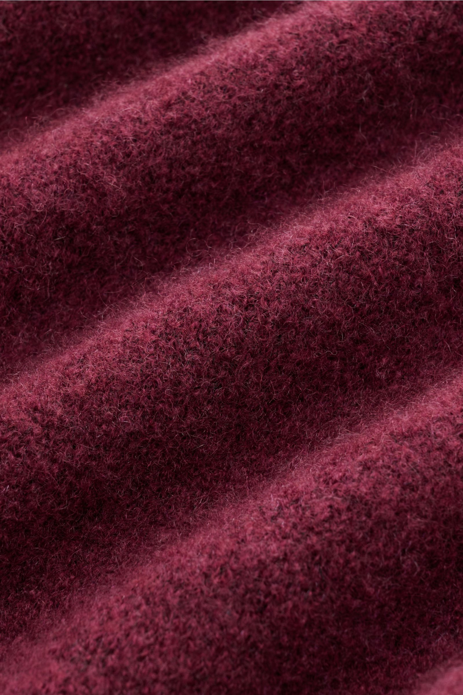 Close-up photo from an angled perspective of the fabric texture of the Filippo de Laurentiis Rundhalspullover bordeaux showing a mix of cashmere, silk, and premium microfiber with a very soft, voluminous feel, medium-fine knit pattern, slim fit, round nec