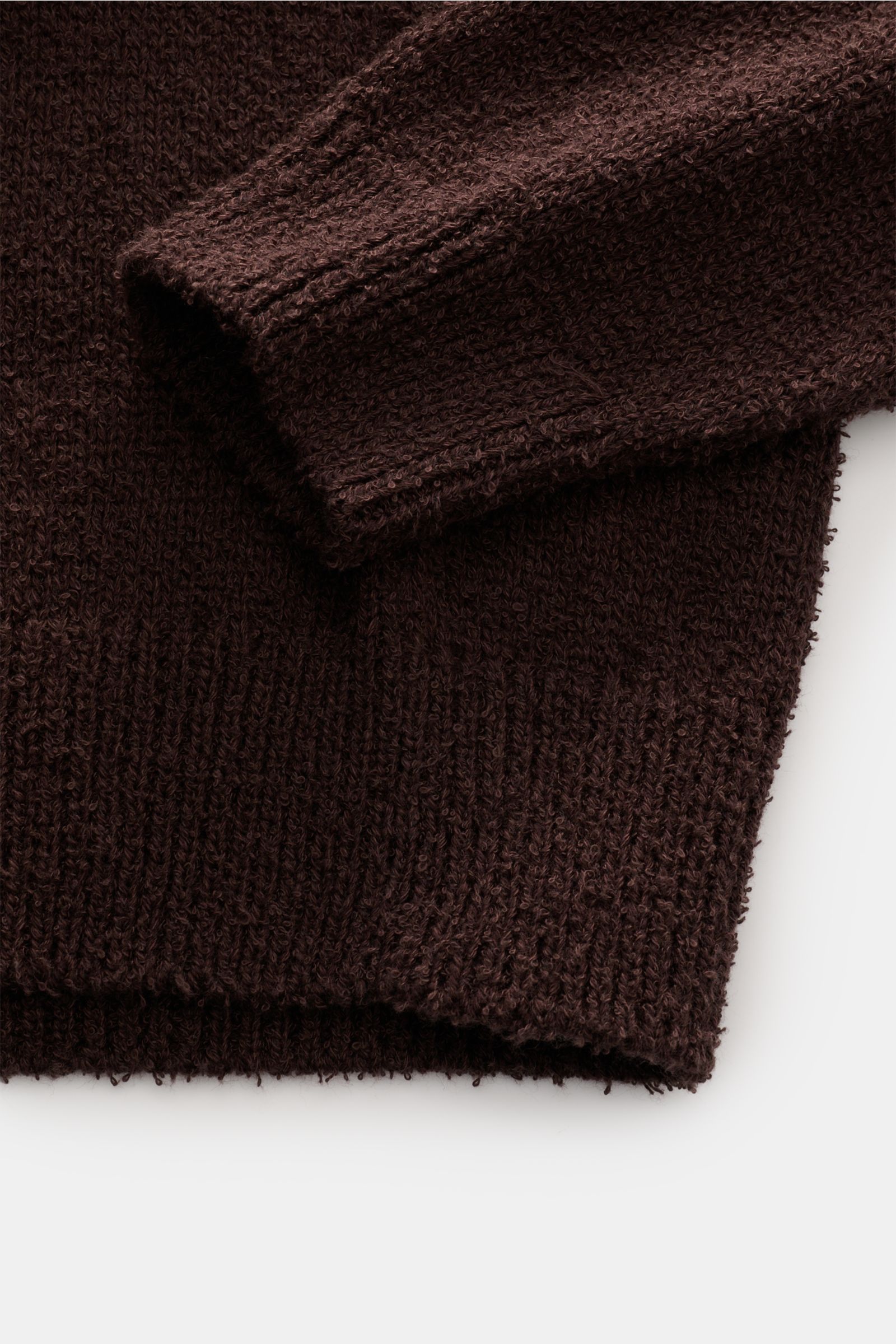 Close-up of the sleeve and hem of a dark navy Closed Rundhalspullover navy, photographed from above, showing boucle knit texture.

Description: Dieser relaxte Pullover aus Baumwoll-Mix mit Wolle in Bouclé-Strick vom Hamburger Label CLOSED ist ein lässi