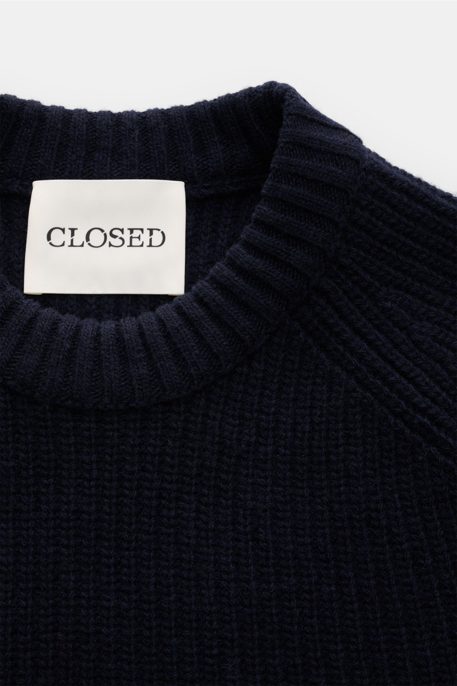 Top-down close-up of Closed Rundhalspullover navy showing ribbed round neckline and chunky rib knit texture, pure wool.

Wandelbarer Klassiker vom Hamburger Label CLOSED: Reine Wolle, markantes Rippstrick-Design und ein schlichter Rundhalsausschnitt ma