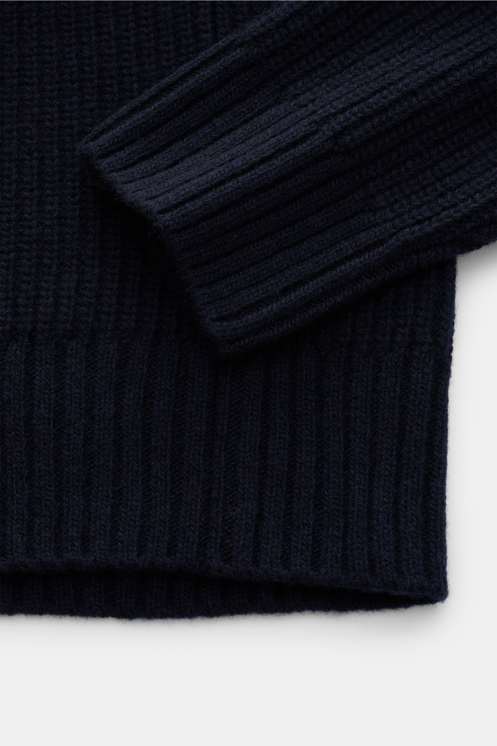 Close-up shot from above of the ribbed cuff and hem of the Closed Rundhalspullover navy, made of pure wool with a soft feel and coarse rib knit design.

Description: Wandelbarer Klassiker vom Hamburger Label CLOSED: Reine Wolle, markantes Rippstrick-De