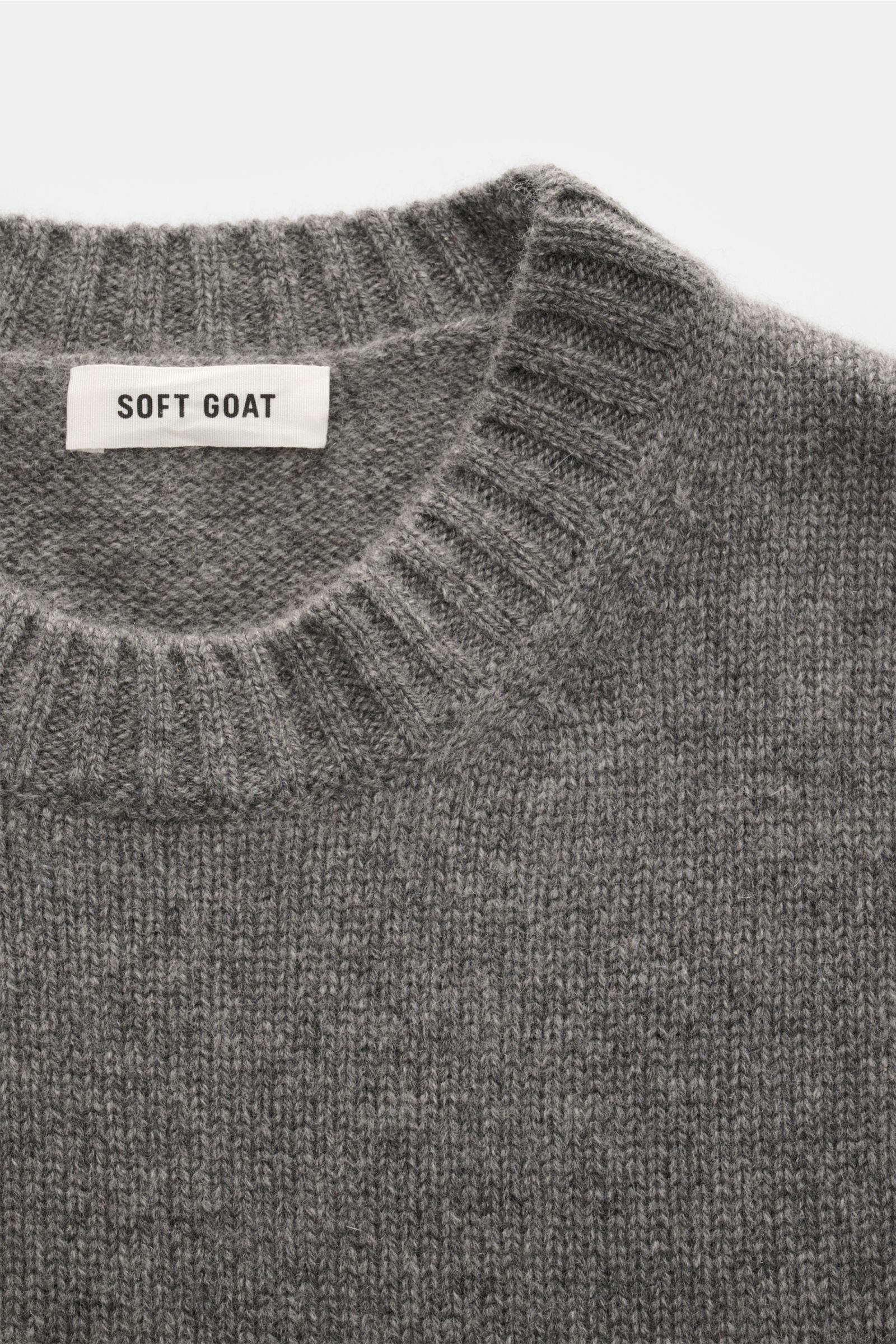 Soft Goat Cashmere Rundhalspullover grau, nah fotografiert von oben, nachhaltiger, superweicher Slim Fit Pullover mit Rundhalsausschnitt und breiten Rippbündchen.